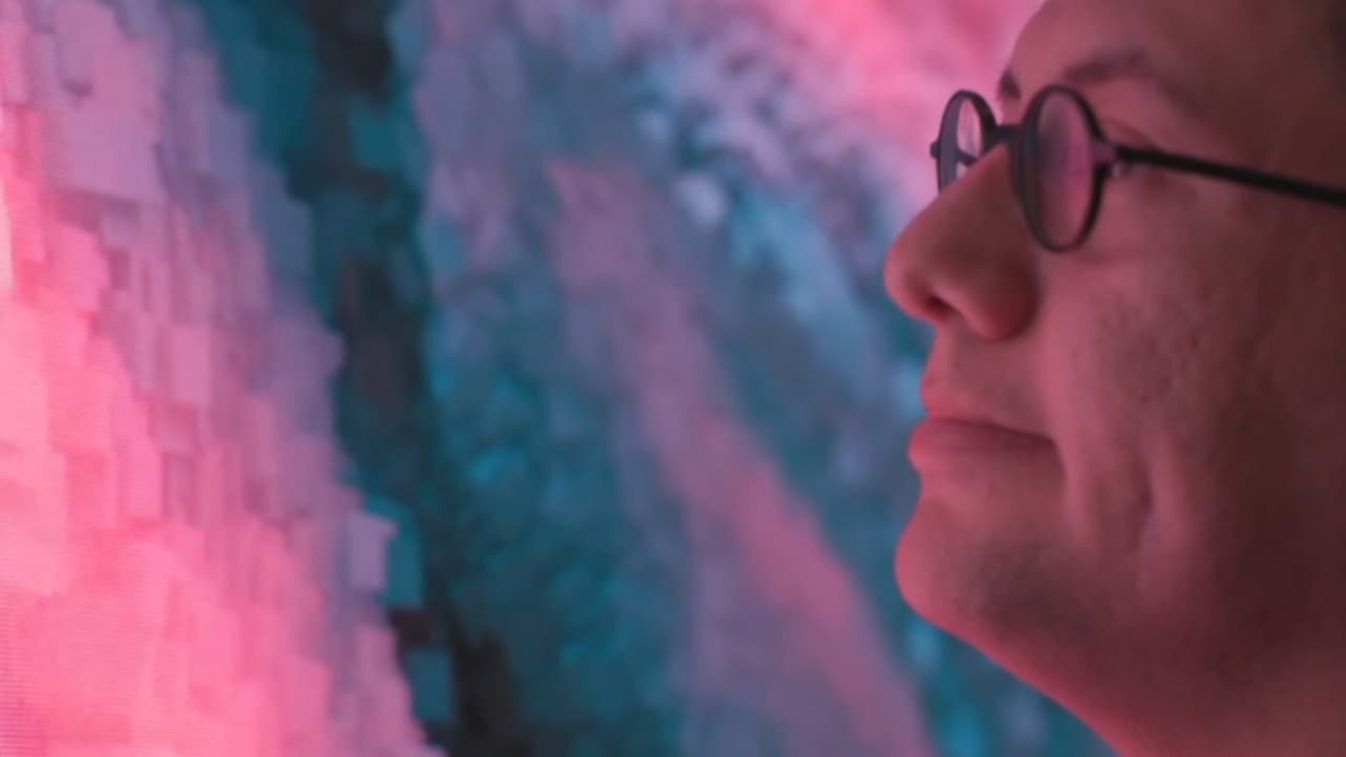 A close shot of Refik Anadol watching one of his pieces