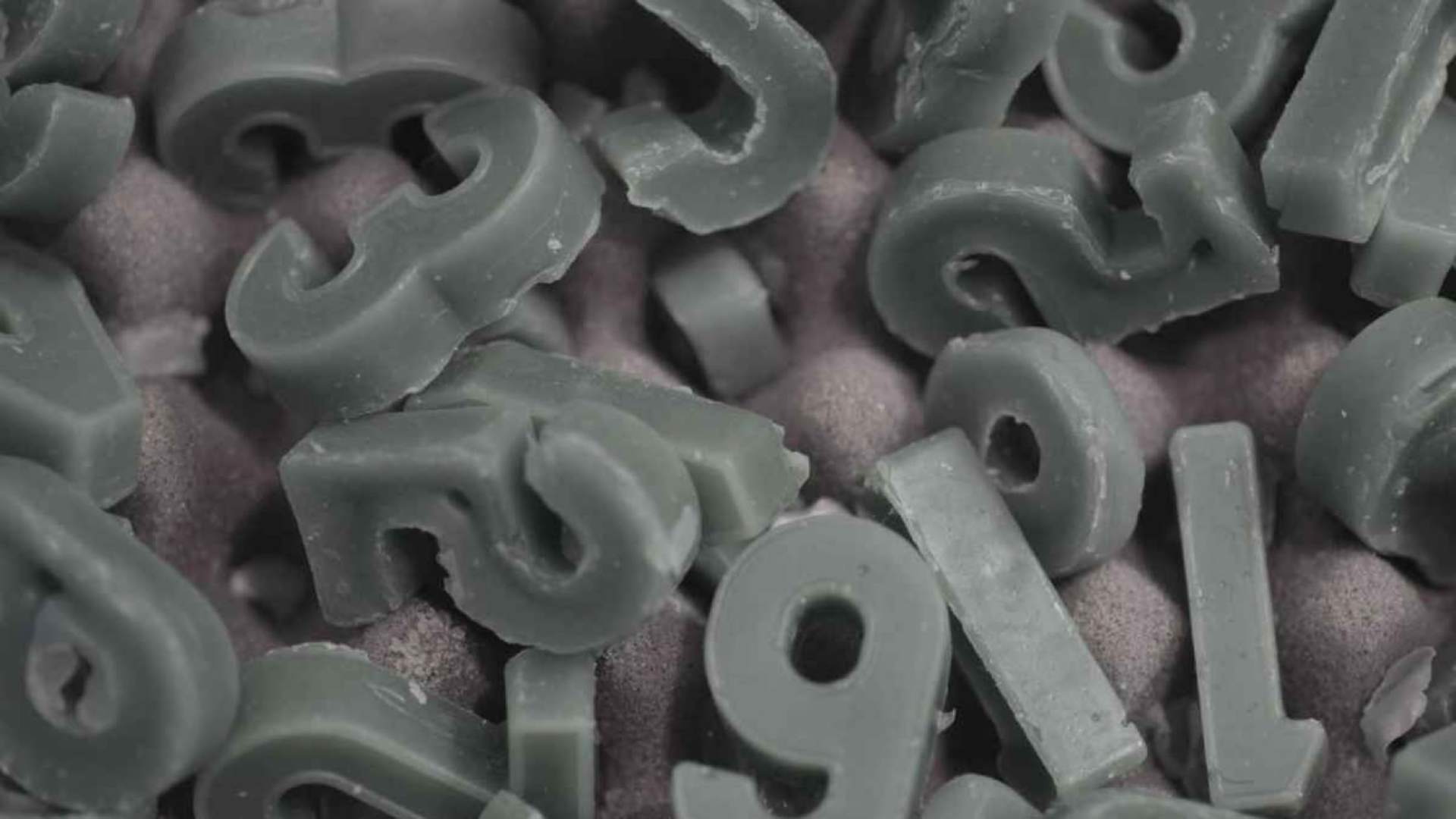 Numbers wade out of wax, used by Mohammed Kazem in one of his art pieces using latitude and longitude co-ordinates.