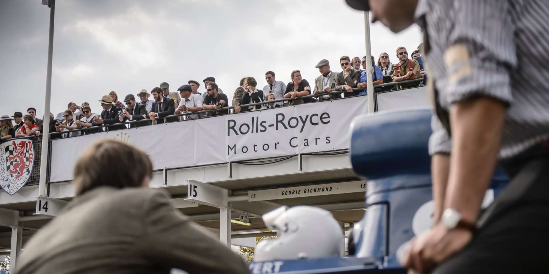 Crowd of spectators clad in the fashion of bygone eras at the Rolls-Royce Goodwood Revival experience.