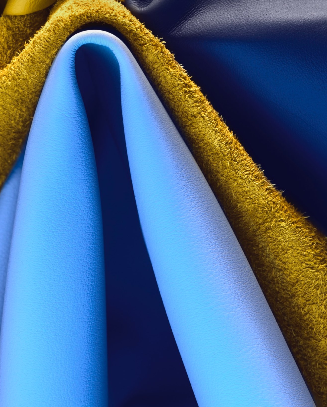 A close-up shot of different shades of blue folded leathers and a yellow cloth