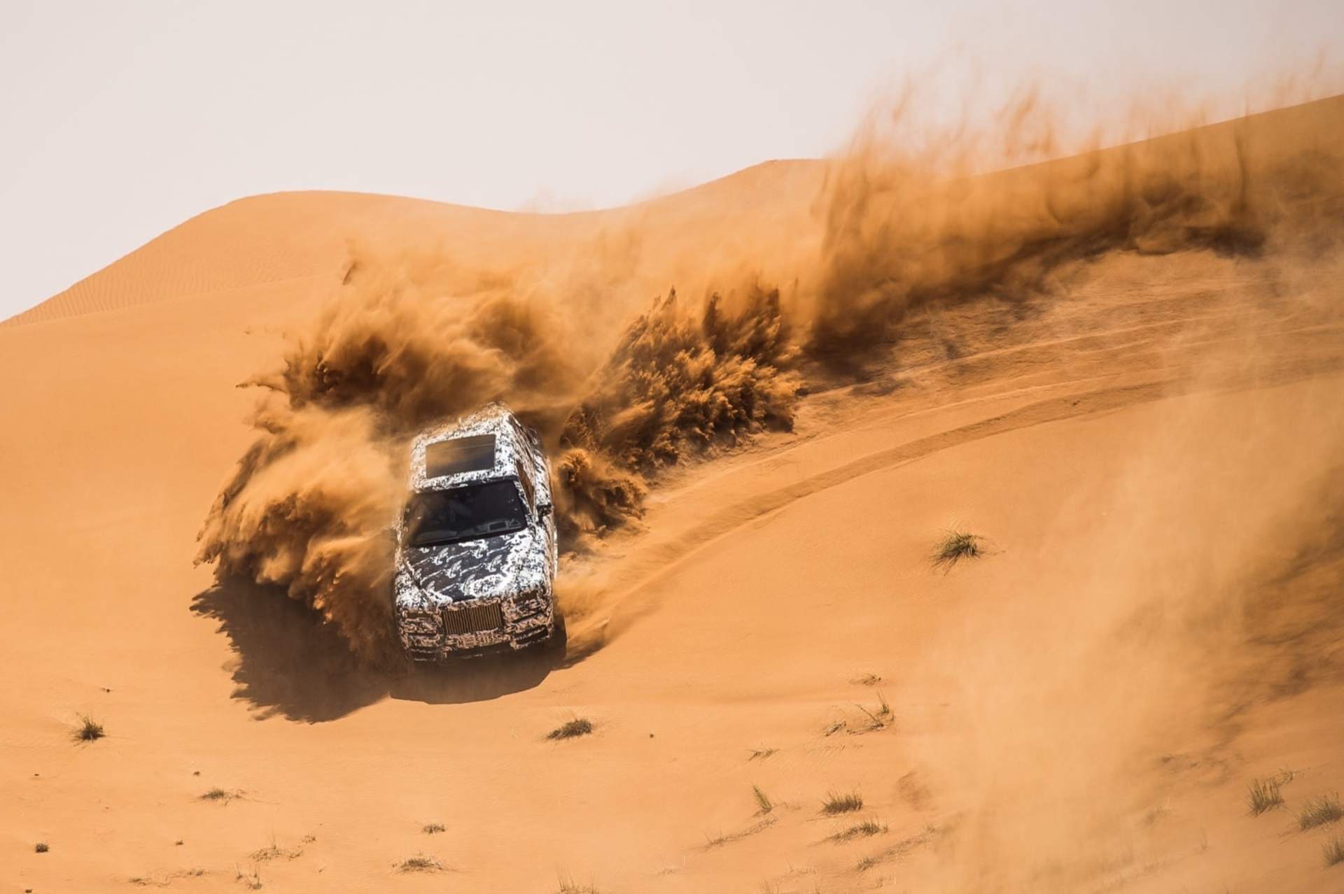 A Rolls-Royce Cullinan motor car drives through a desert
