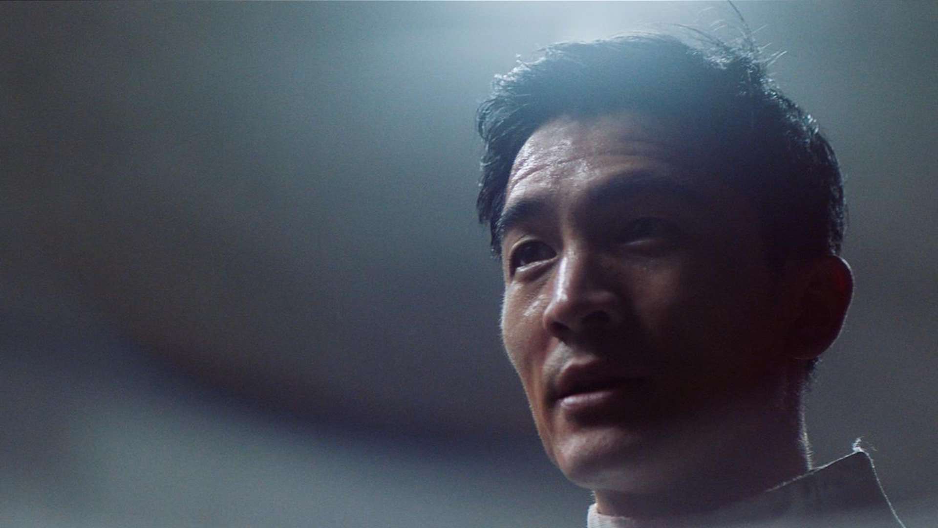 A man stares into the distance after removing his fencing helmet