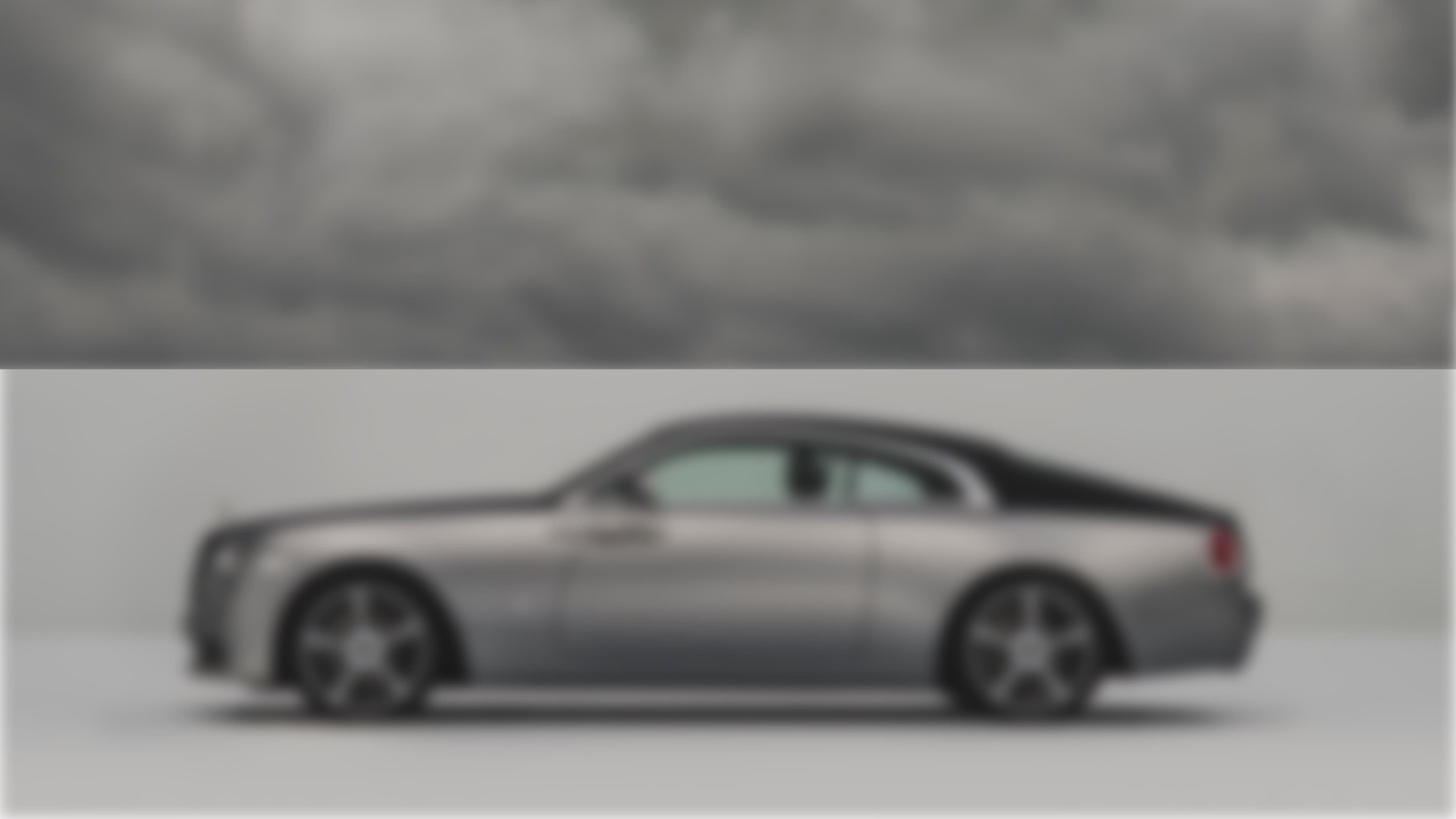 Side exterior view of the Rolls-Royce Wraith motor car with grey clouds above