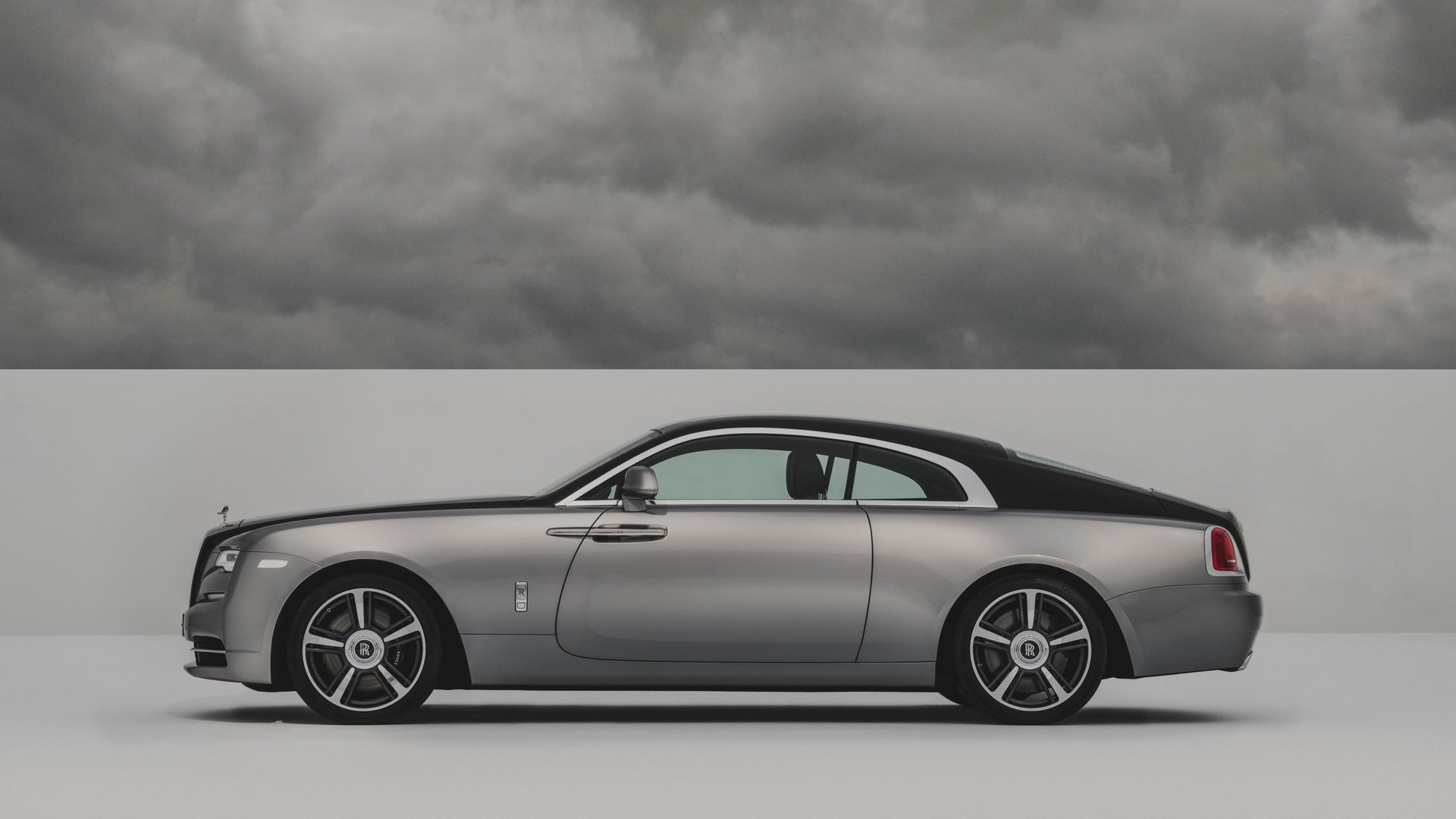 Side exterior view of the Rolls-Royce Wraith motor car with grey clouds above