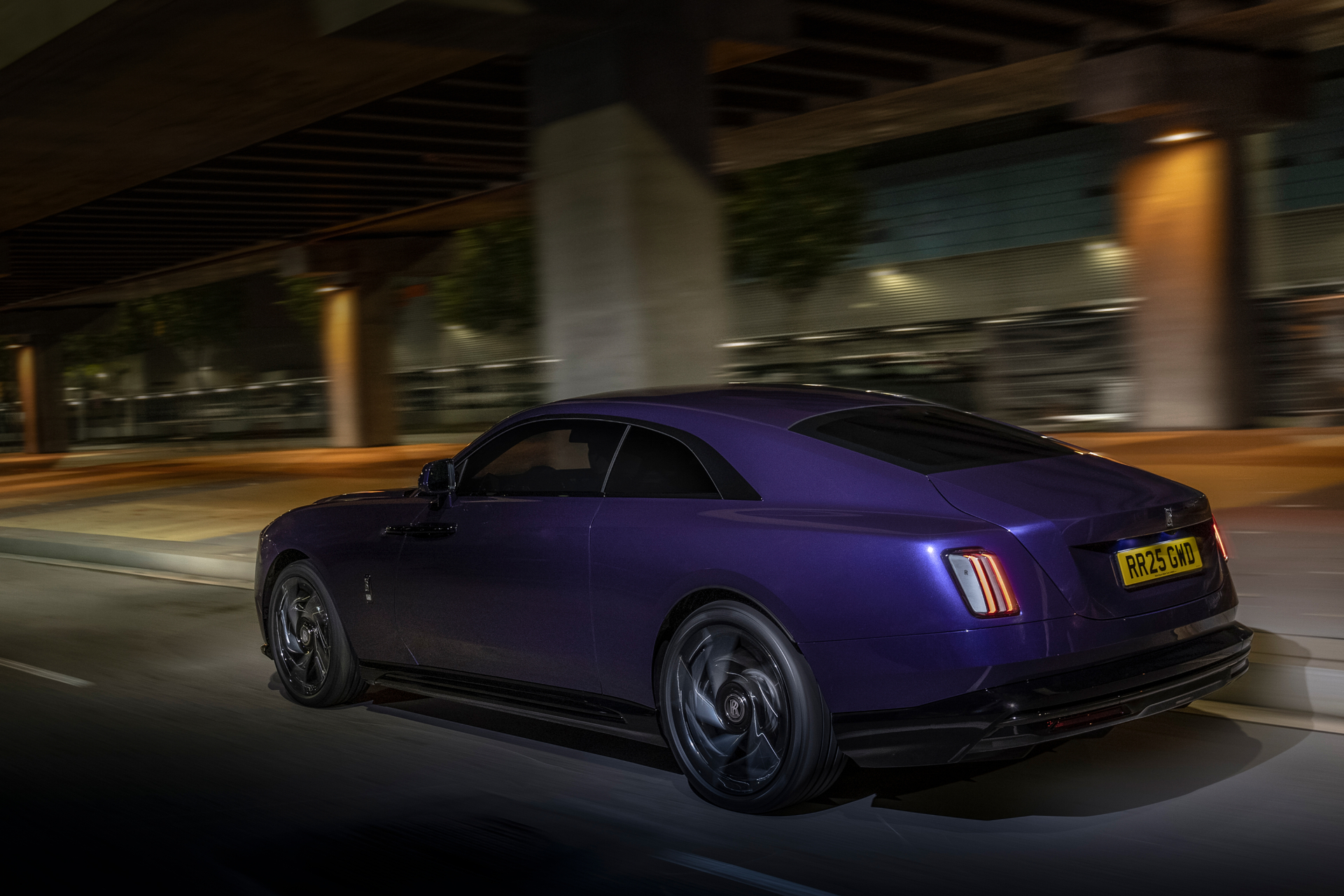 Action shot of the purple Black Badge Spectre driving quickly through the street.