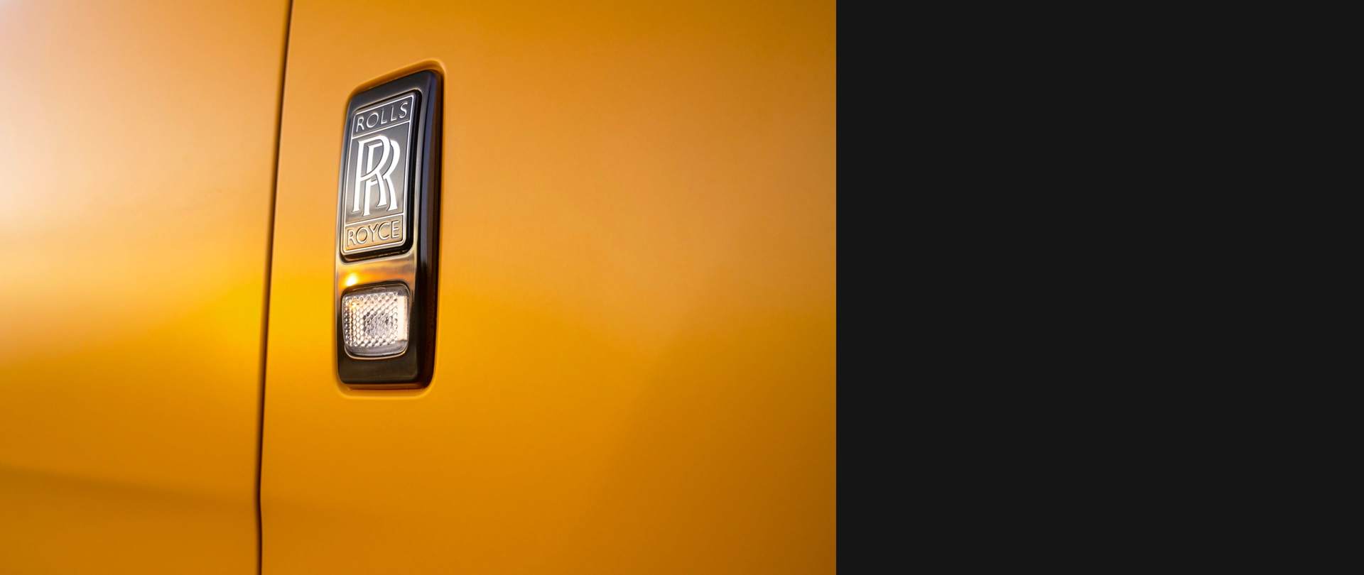 Close-up of Rolls-Royce Black Badge of Honour detail on exterior of Cullinan Capella motor car
