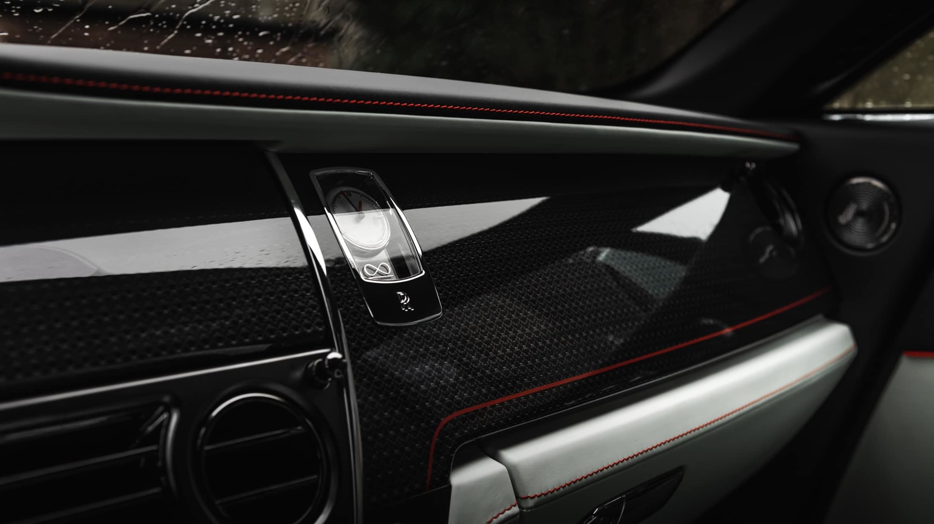 Bespoke dashboard and clock detail with Koi Red detailing inside the Rolls-Royce Black Badge Wraith Inception motor car