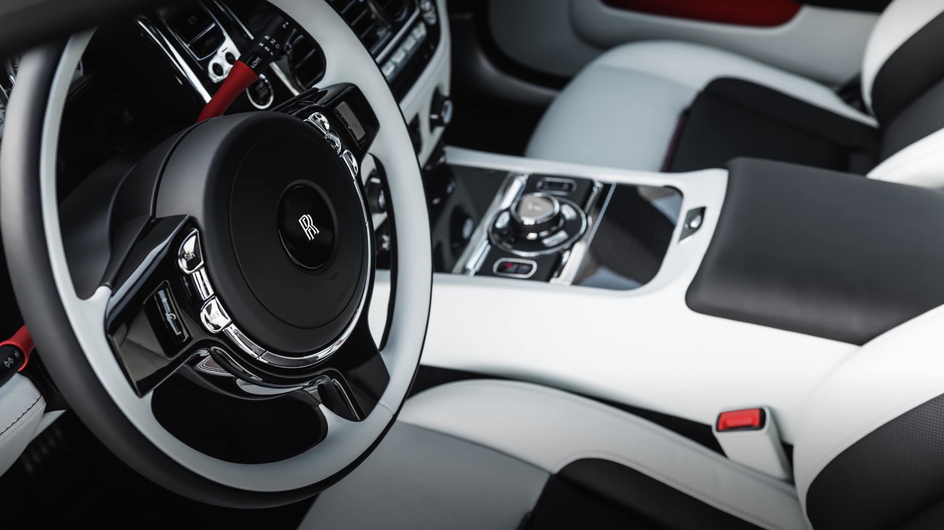 Interior details of the steering wheel with Koi Red accents in the bespoke Rolls-Royce Black Badge Wraith Inception motor car