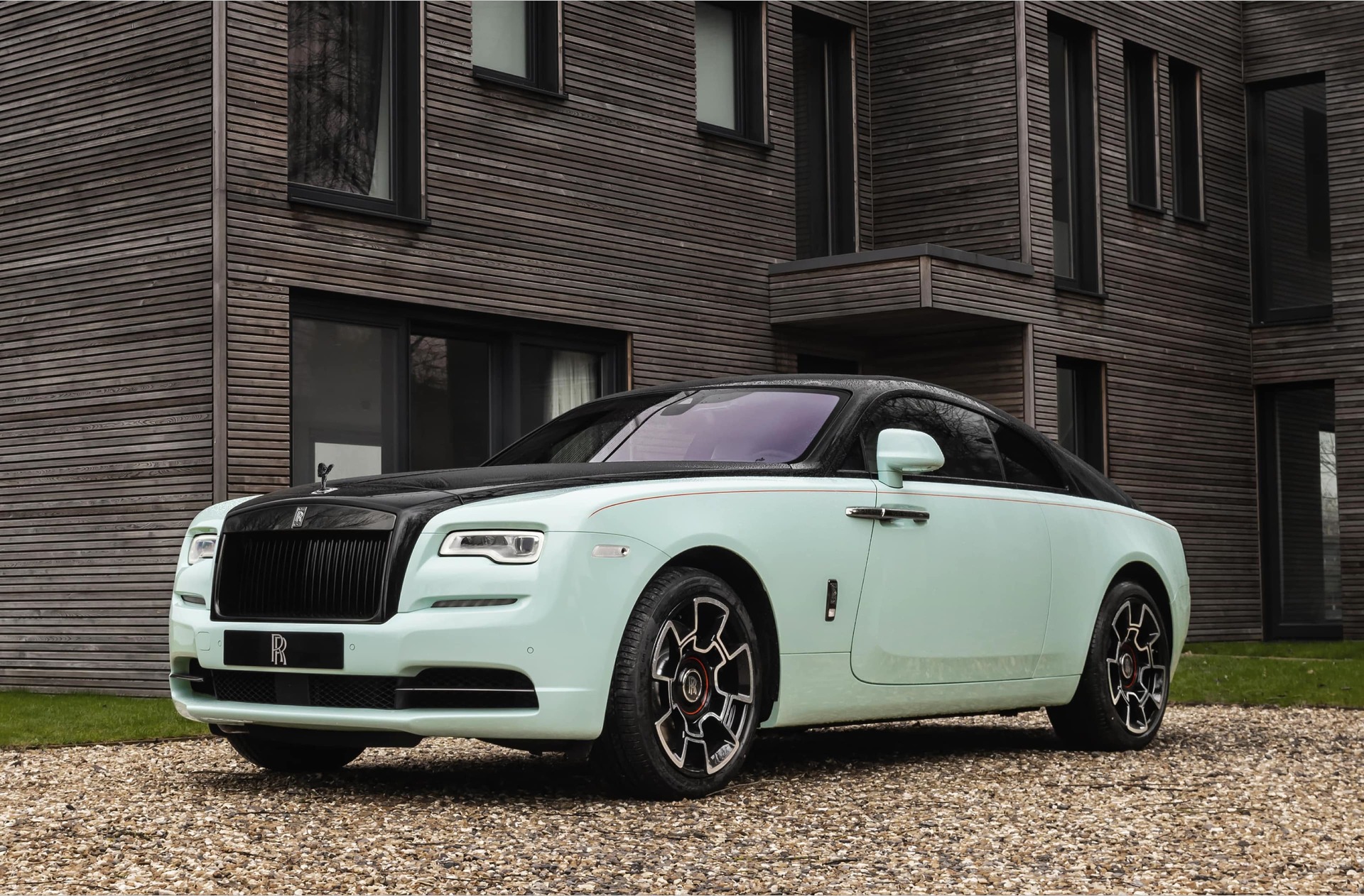 3/4 front exterior of bespoke Rolls-Royce Black Badge Wraith Inception motor car parked outside modern home