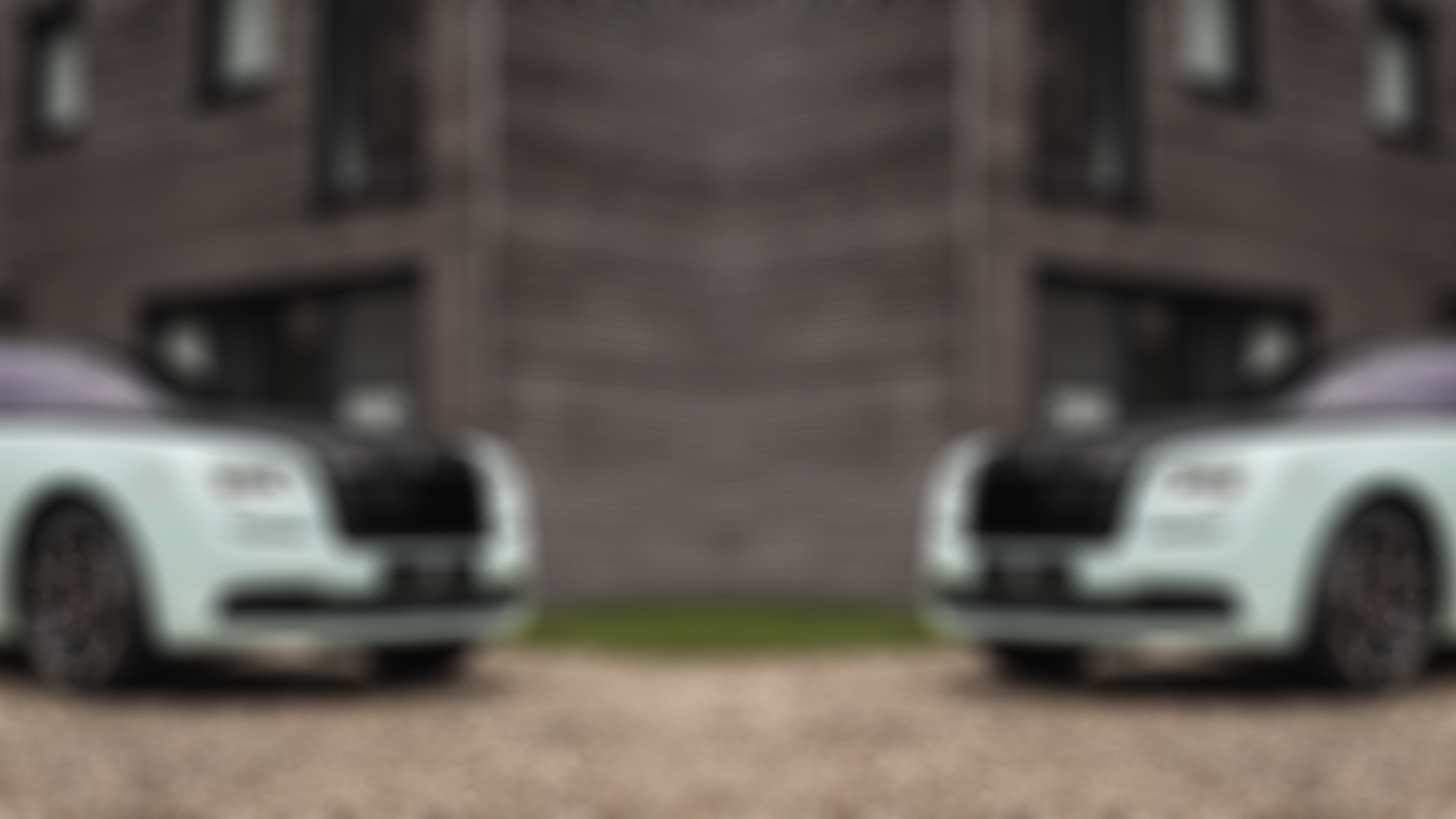 Reflected image of bespoke Rolls-Royce Black Badge Wraith Inception motor car parked outside modern home
