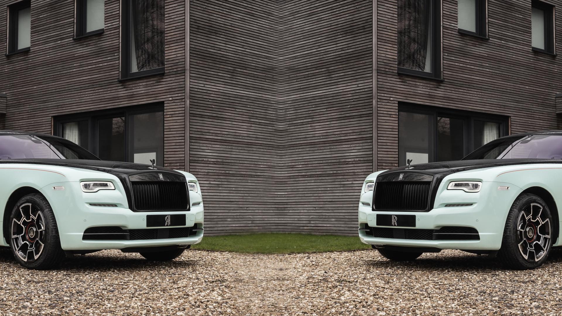Reflected image of bespoke Rolls-Royce Black Badge Wraith Inception motor car parked outside modern home