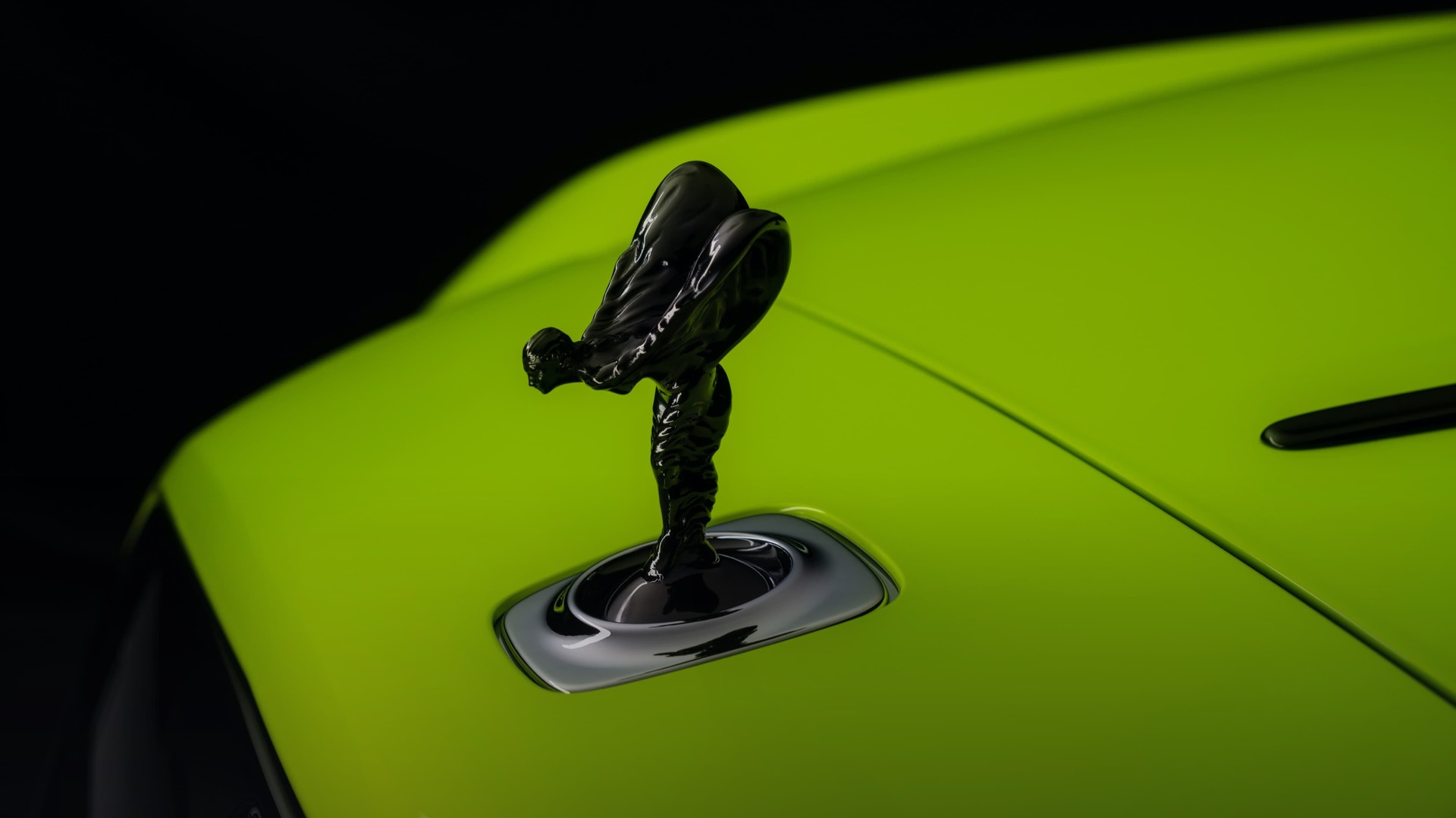 Close-up view of the front of a Lime Rock Green Black Badge Wraith with a Spirit of Ecstasy.