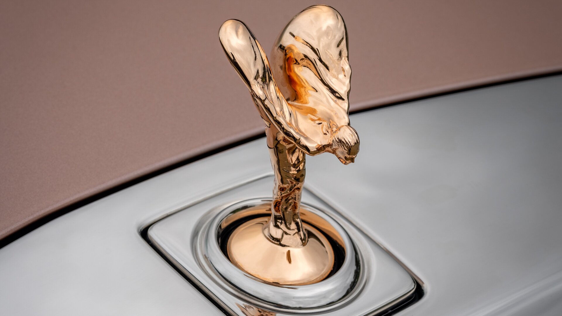 Close up of a gold plated Spirit of Ecstasy sitting on top of the bonnet.