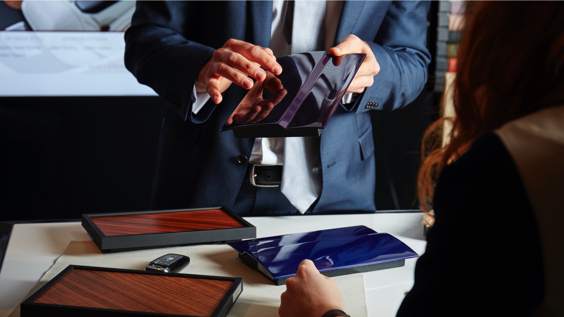 A person holding a dark purple item used by Rolls-Royce employees to help customer select colours