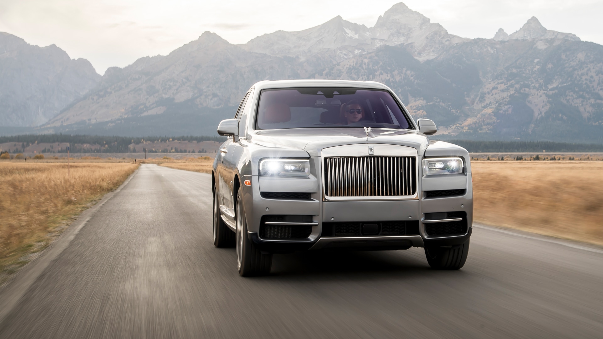 A Rolls-Royce car on the road between the mountains