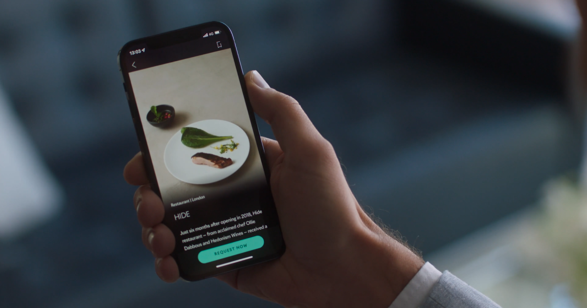 A customer going through the Whispers app on its phone