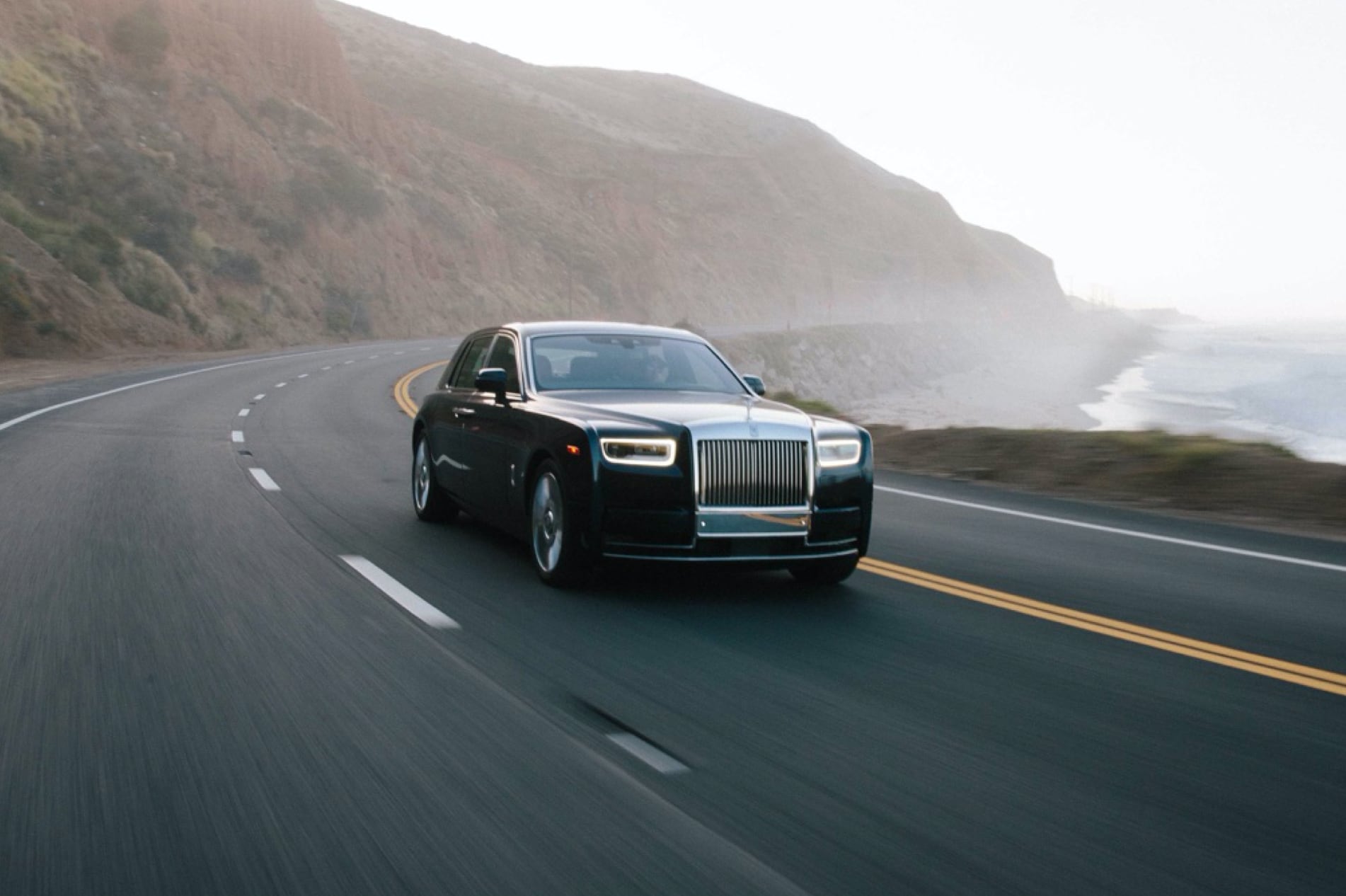 A Rolls-Royce Phantom on the road next to the sea