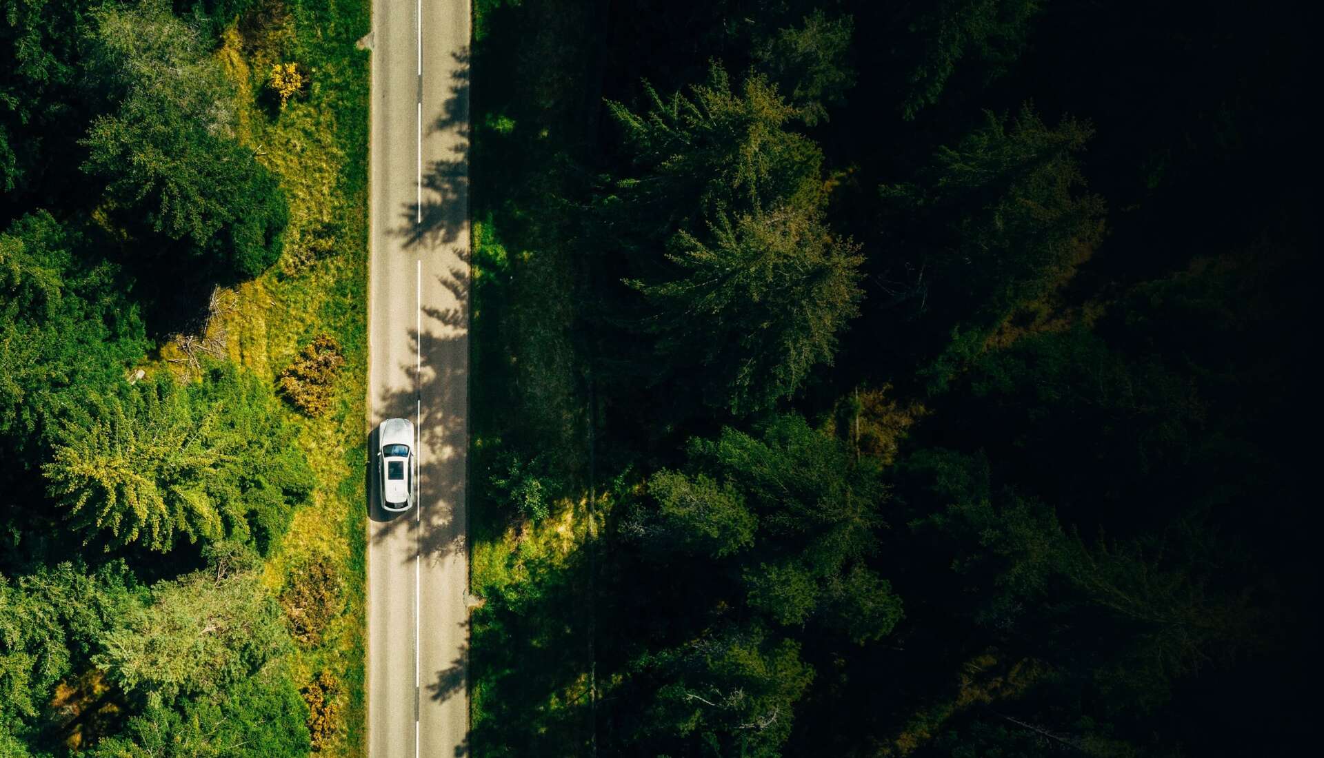 A Rolls-Royce Cullinan driving on the road view from the top