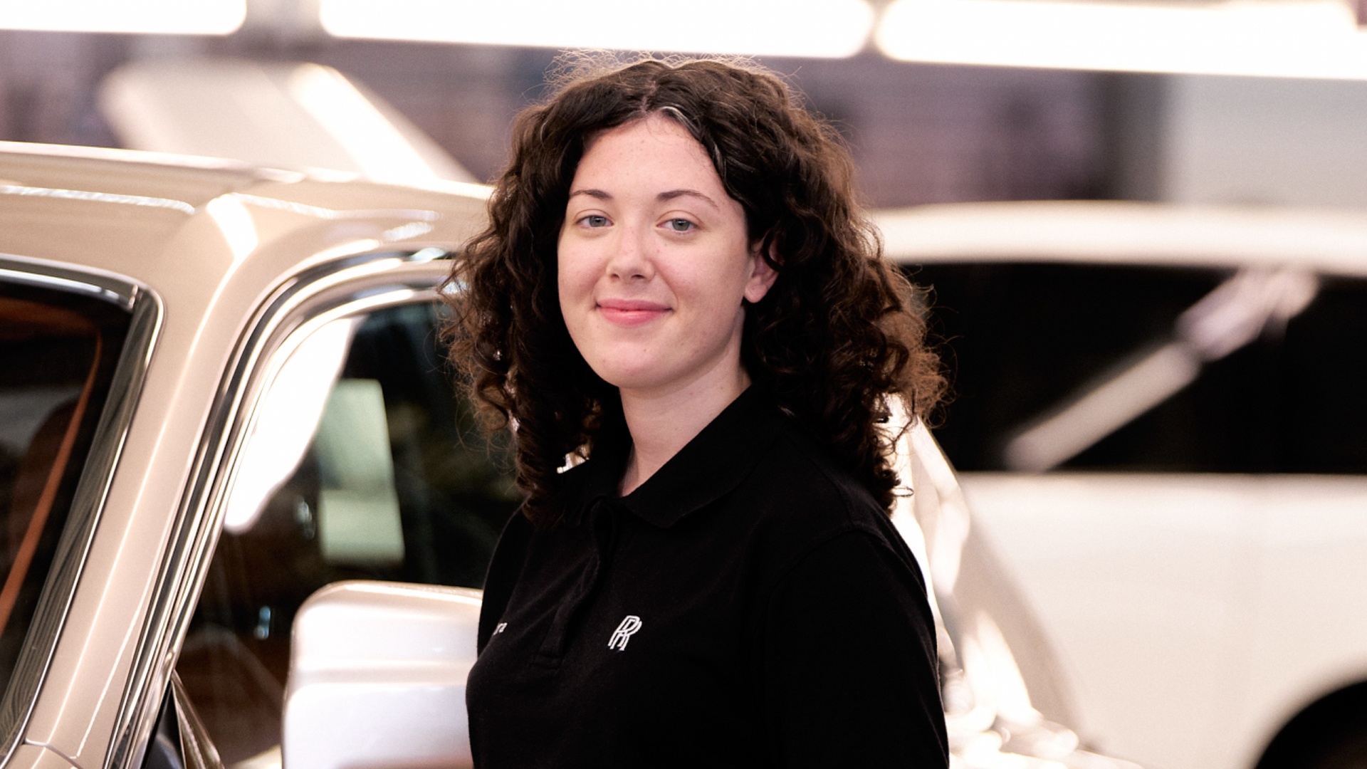  A young female Rolls-Royce graduate wearing a polo shirt with the Rolls-Royce monogram on it
