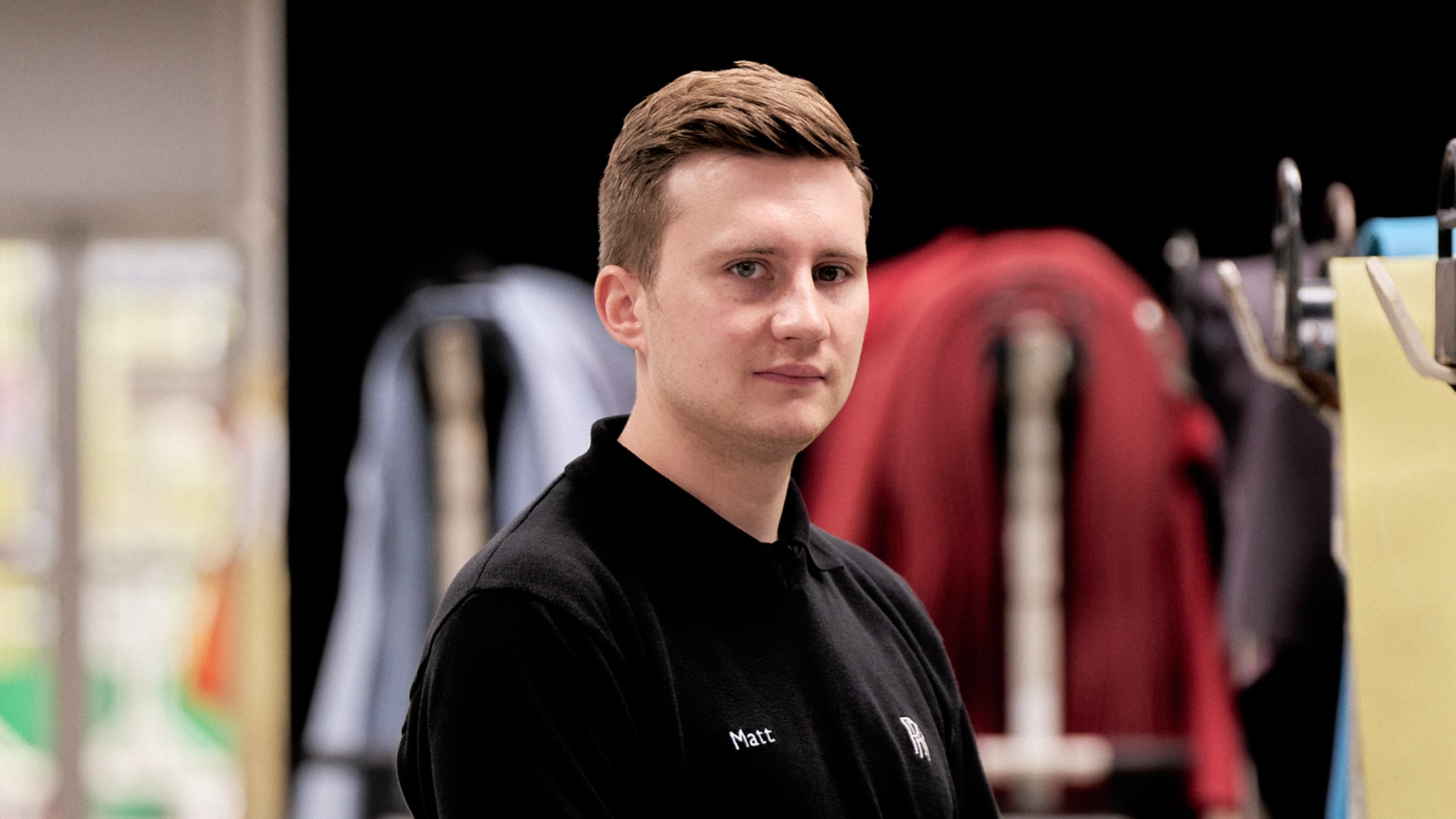 A young Rolls-Royce graduate wearing a polo shirt with the name Matt and the Rolls-Royce monogram on it