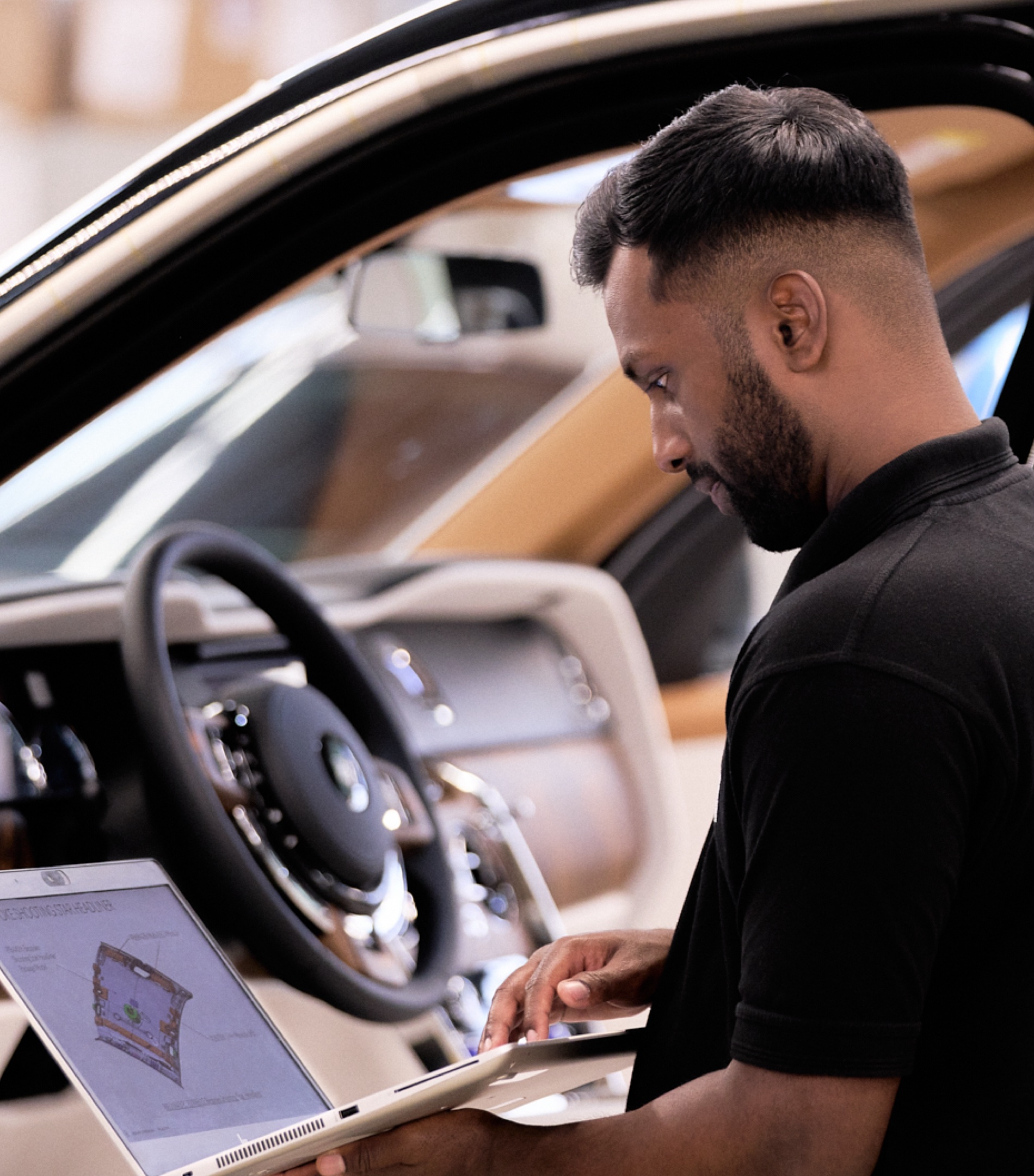 A male Rolls-Royce graduate checking the details of the interior or a Rolls-Royce car