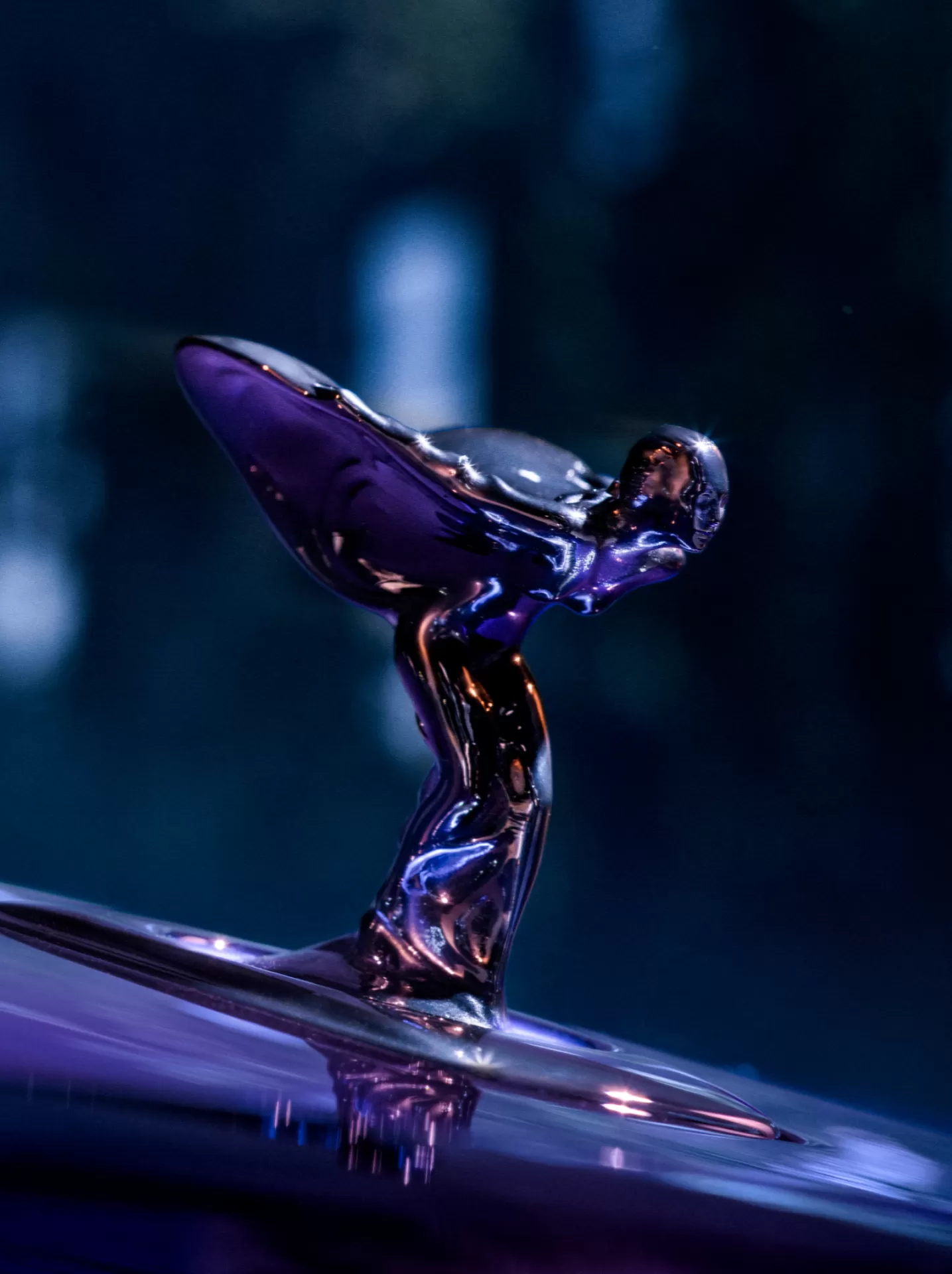 Close up shot of the Spirit of Ecstasy, radiating a purple hue from the purple Black Badge Spectre.