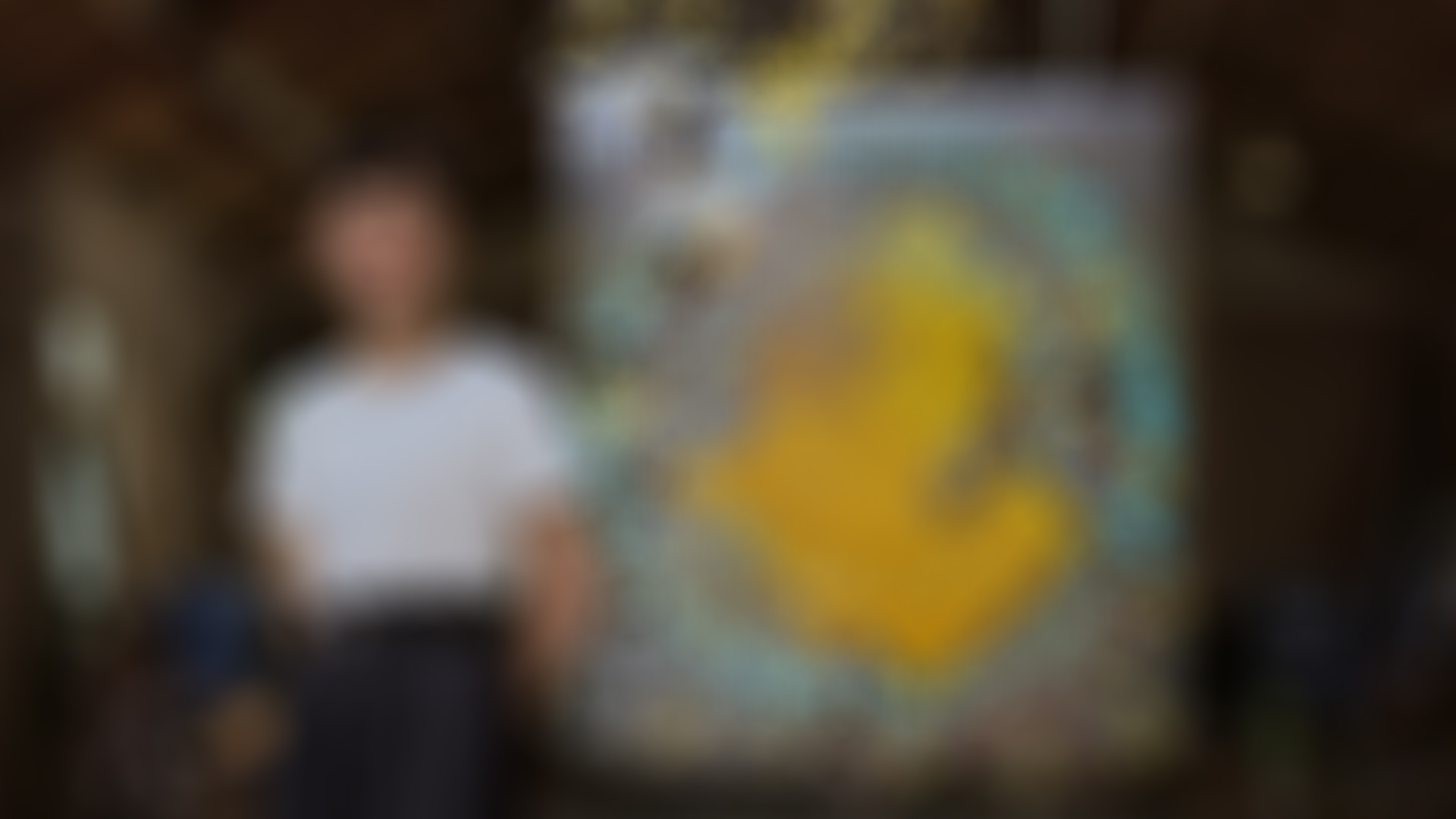 A photo of Bi Rongrong with her artwork in the backgorund