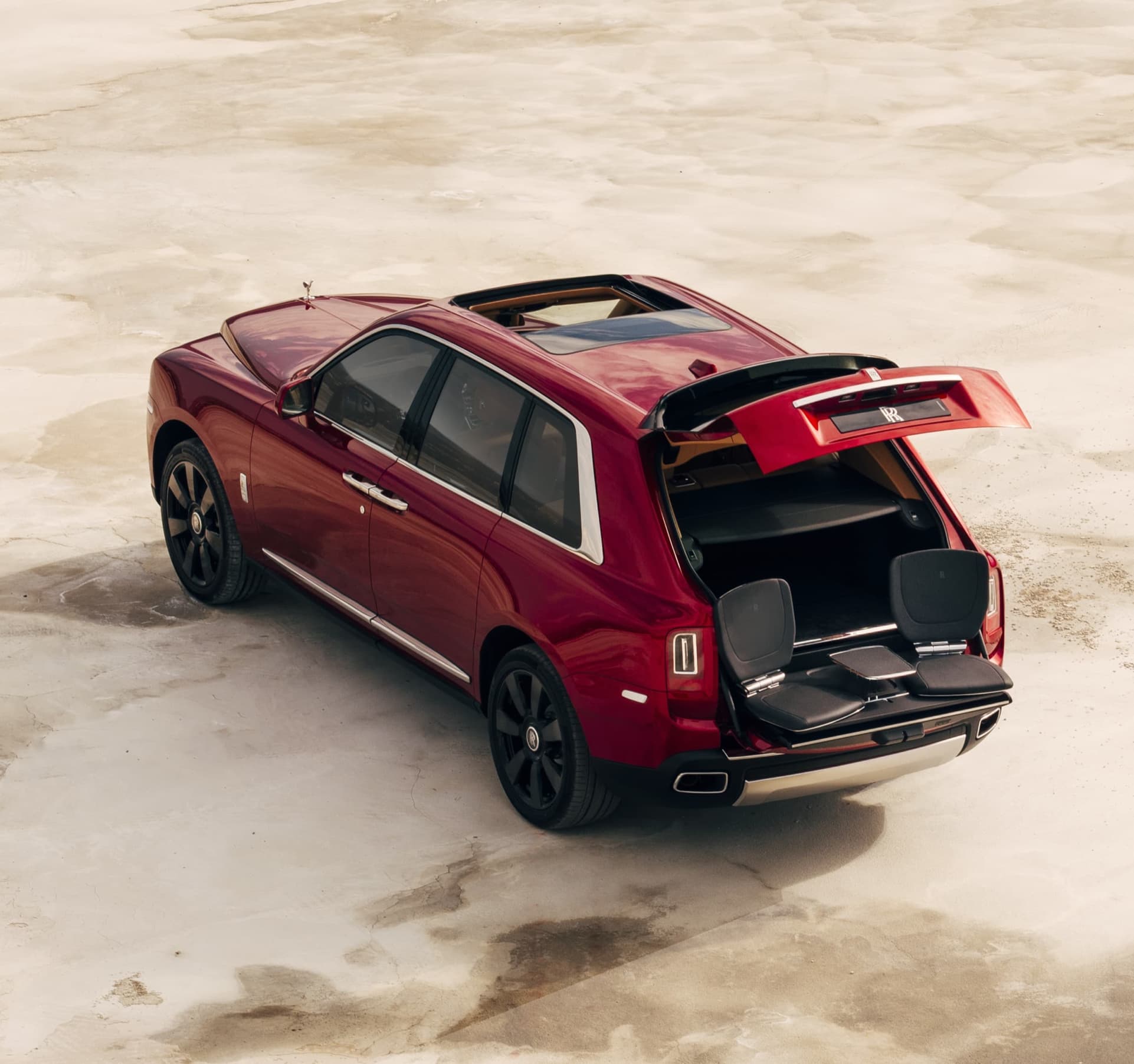Aerial rear view of stationary Rolls-Royce Cullinan motor car with rear door open revealing the bespoke Cullinan Viewing Suite