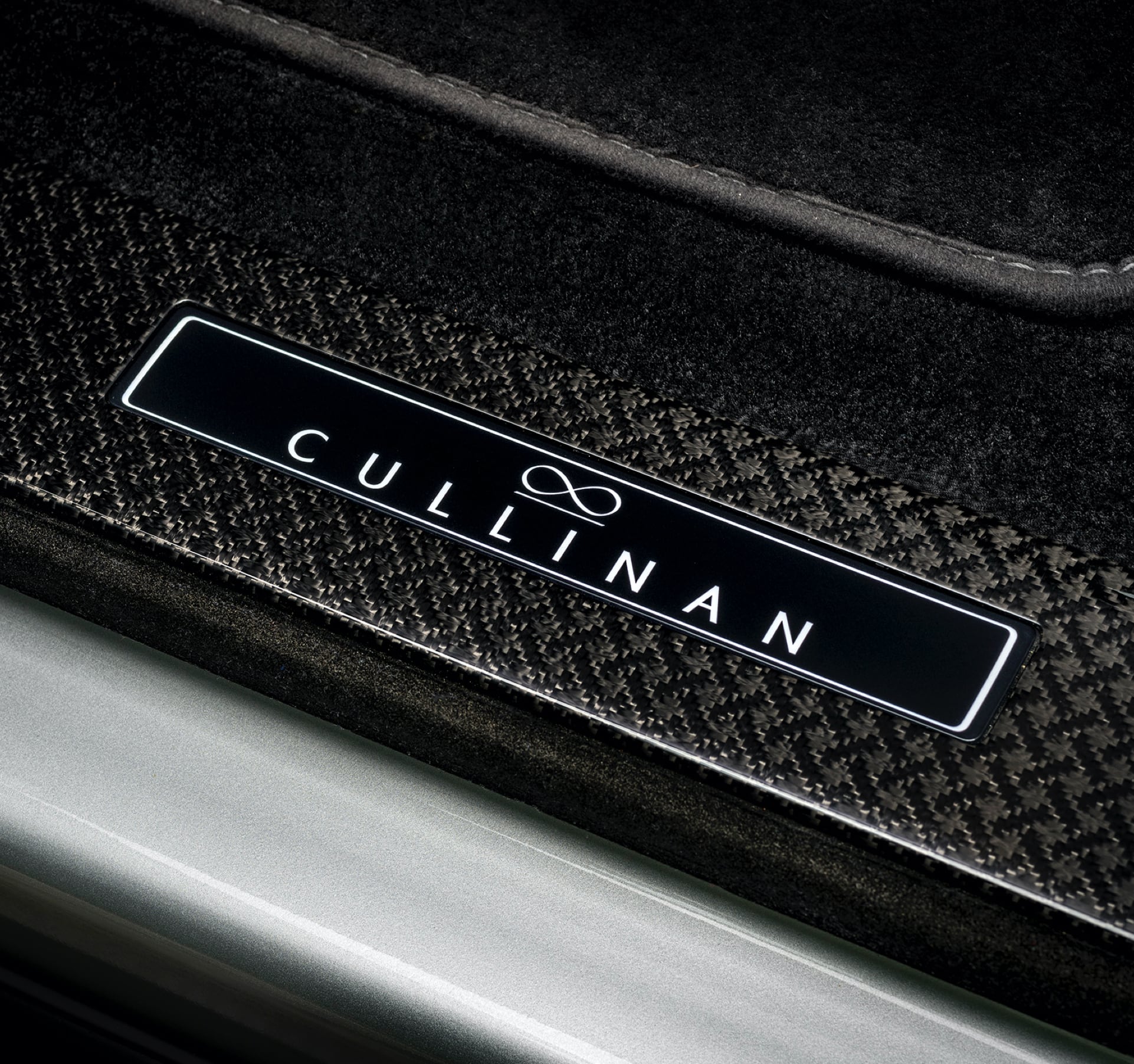 An interior shot of a Rolls-Royce motor car Cullinan with a carbon treadplate