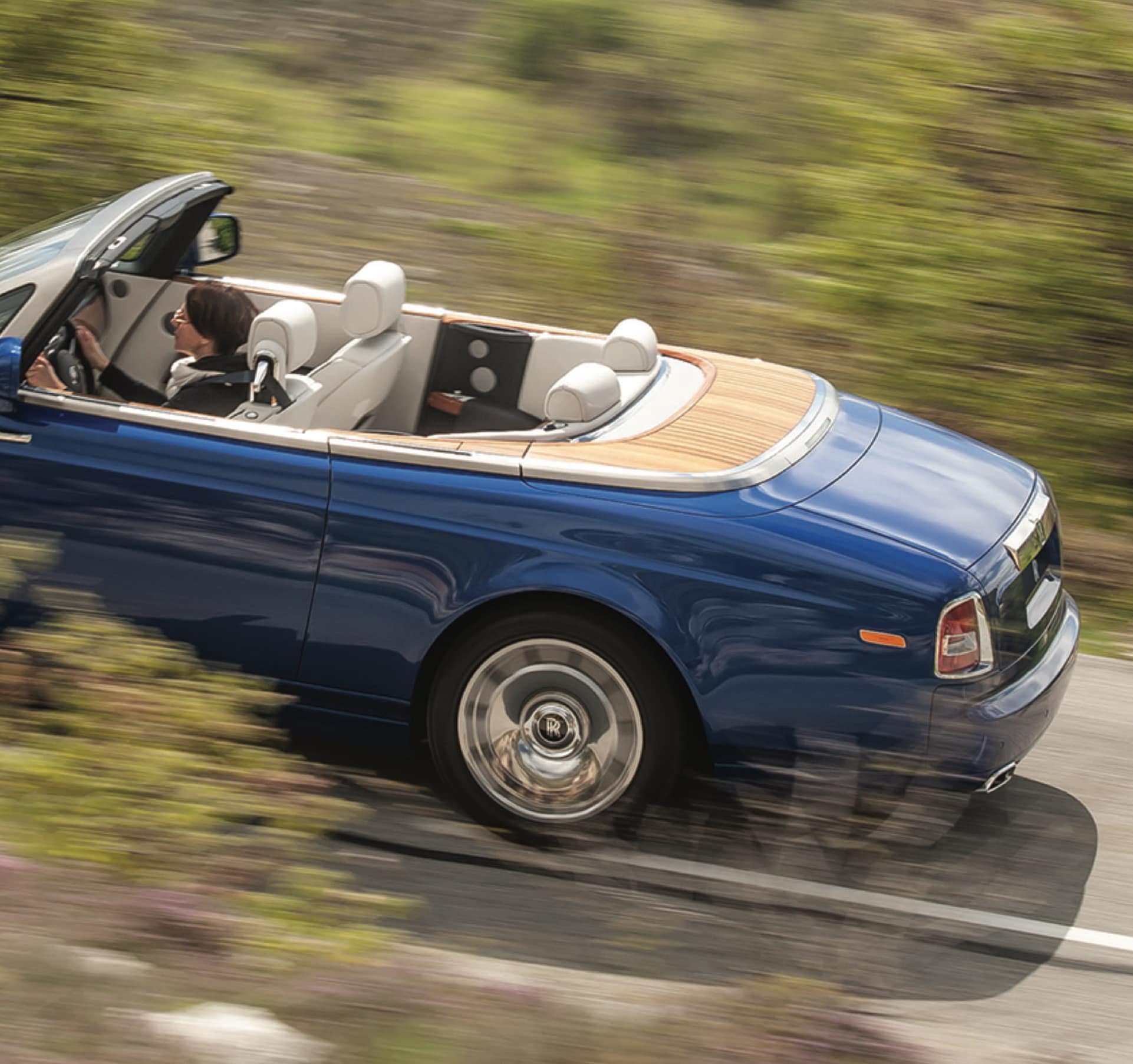 Drophead coupé Rolls-Royce motor car with rear Teak Decking driving on road