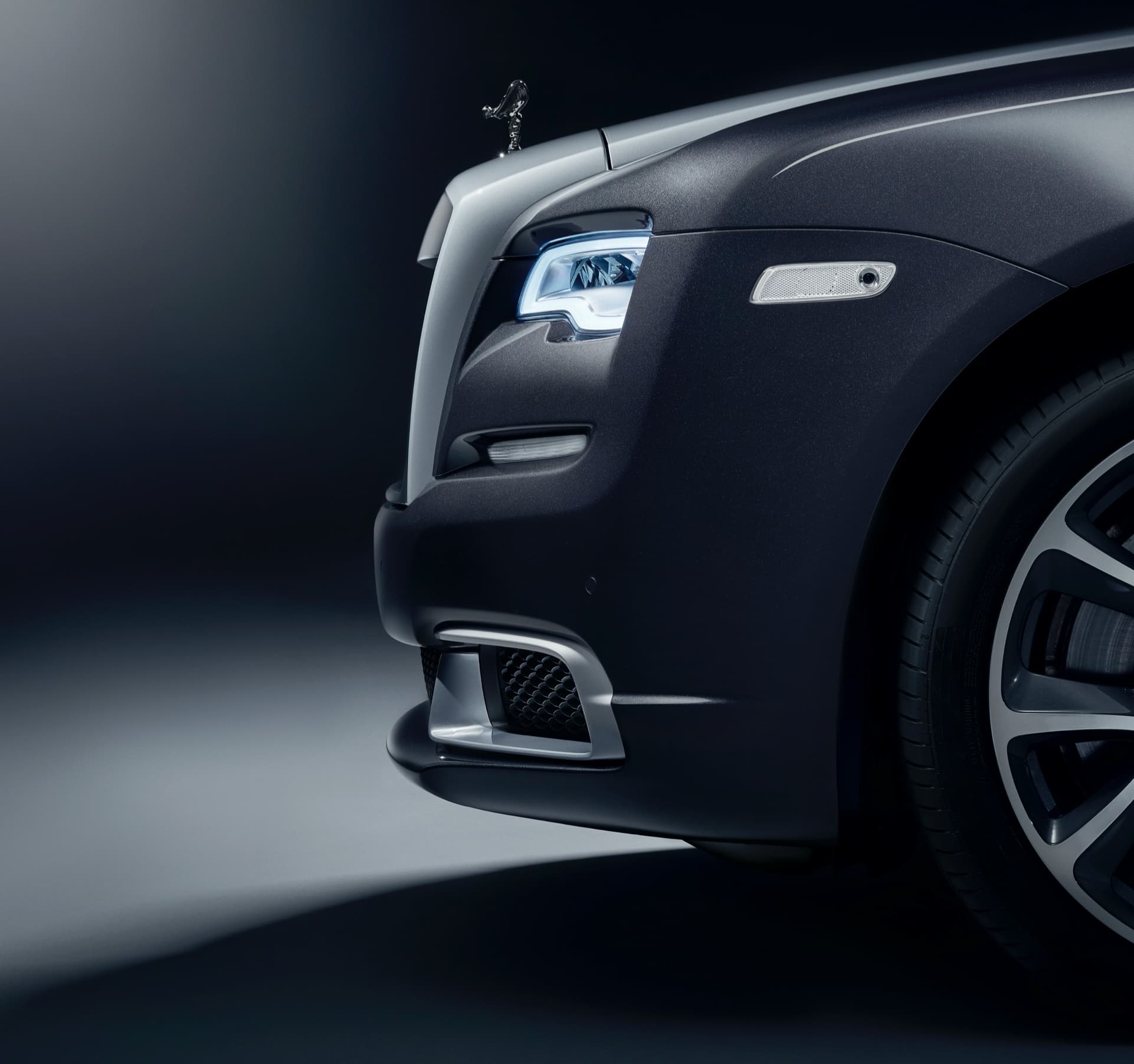 Close-up side view of the front bumper of a dark Wraith with the aero insert.