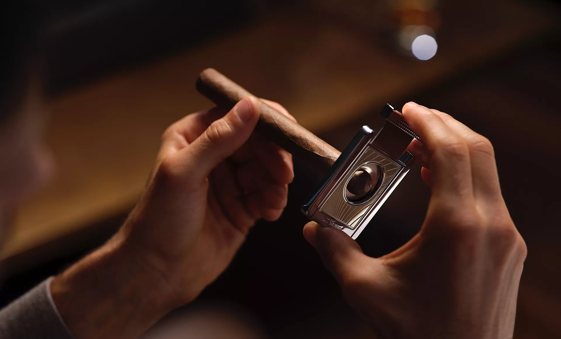 A man lighting up a cigar using the custom lighter