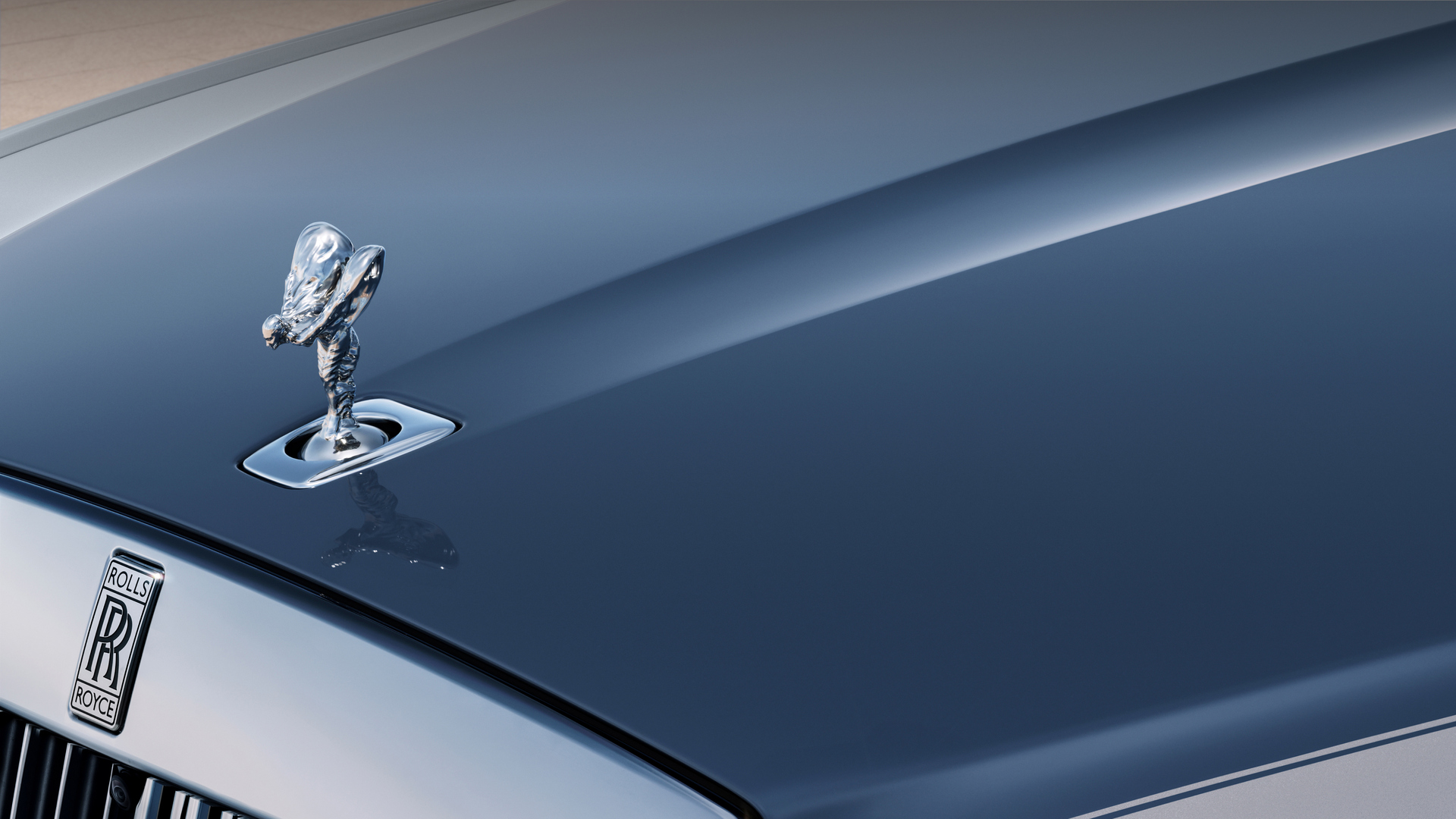 Close up of a silver spirit of ecstasy on a navy blue Ghost Extended SII.
