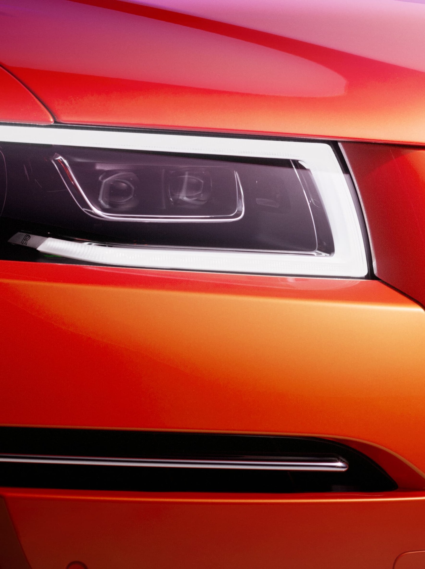 ghost rolls royce 2021 close up of the front headlight turned on of the Orange Metallic Ghost