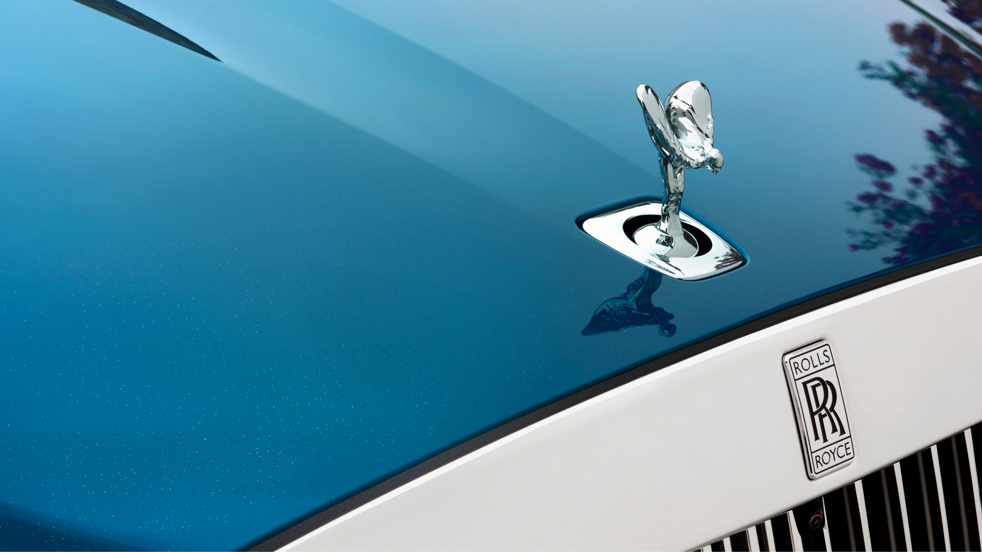 Close up of a silver spirit of ecstasy on a navy blue Ghost SII.