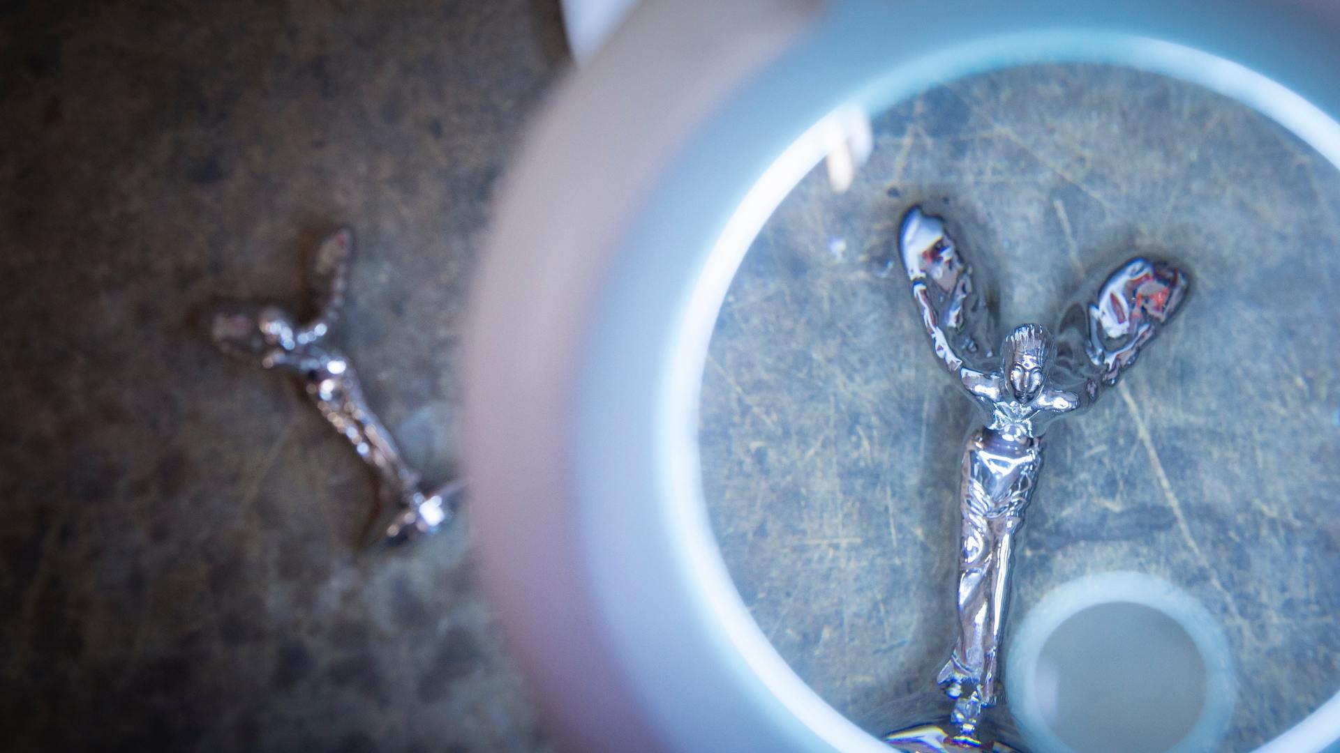 A Spirit of Ecstasy  looked through a magnifying glass