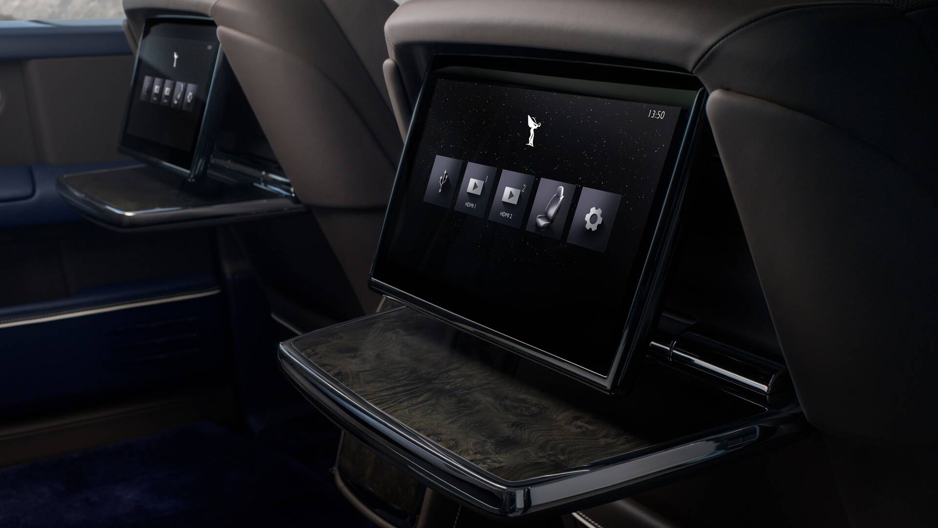 Close up of the backseat interior showcasing the screens that come out of the back of the front seats. 