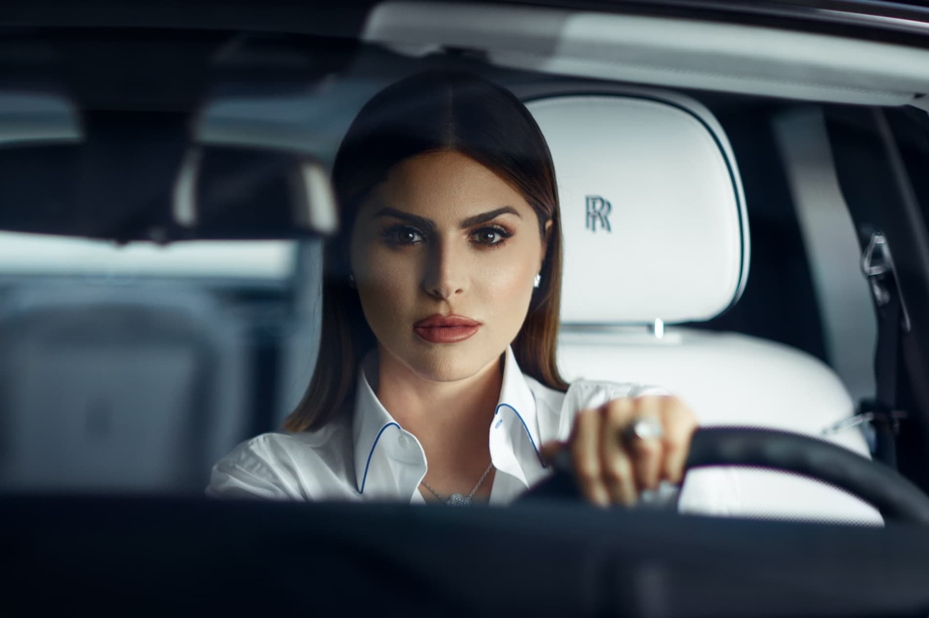 A profile shot of Stephanie Shojaee driving her Rolls-Royce Phantom