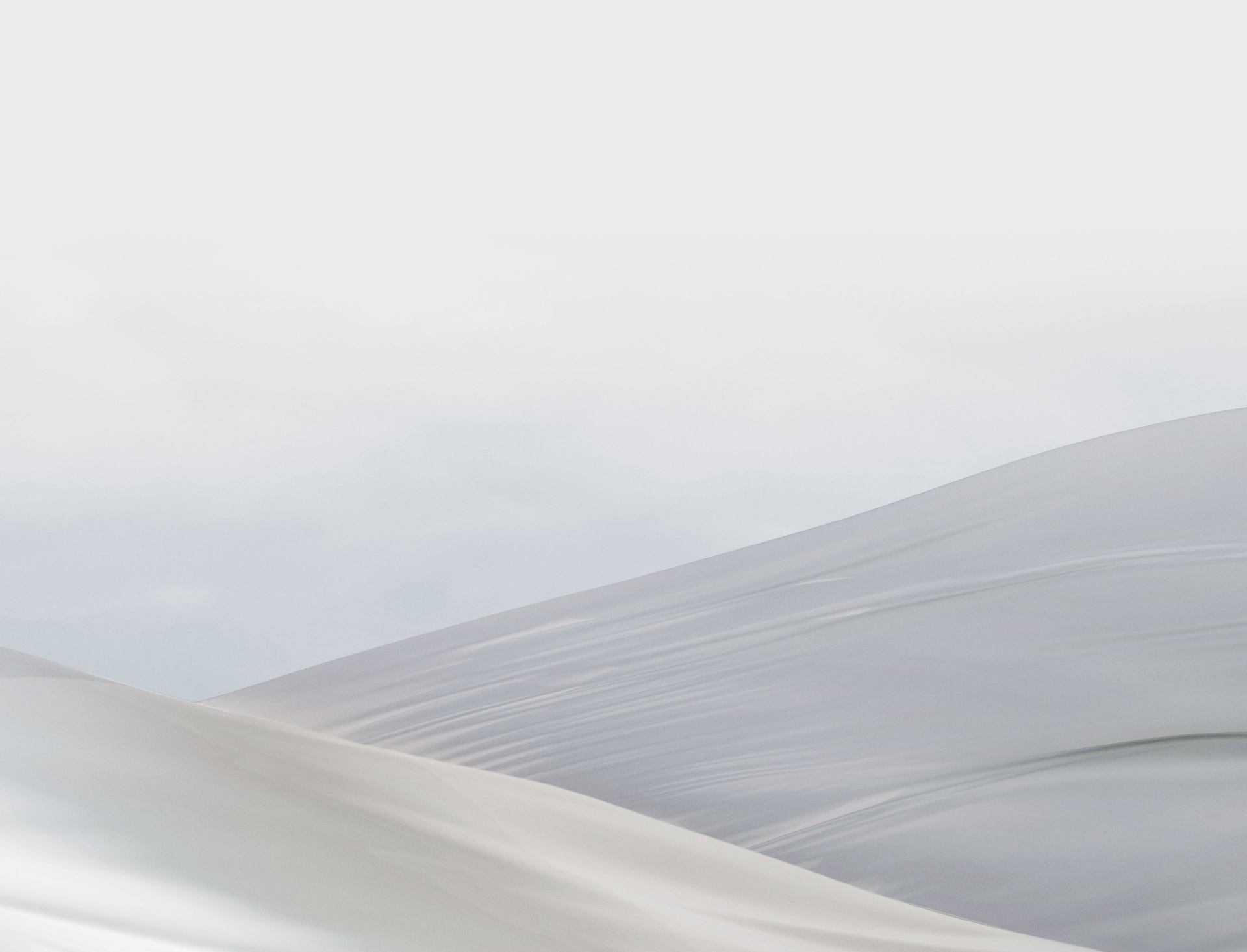 white sky with cream ribbons flowing gently through each other.