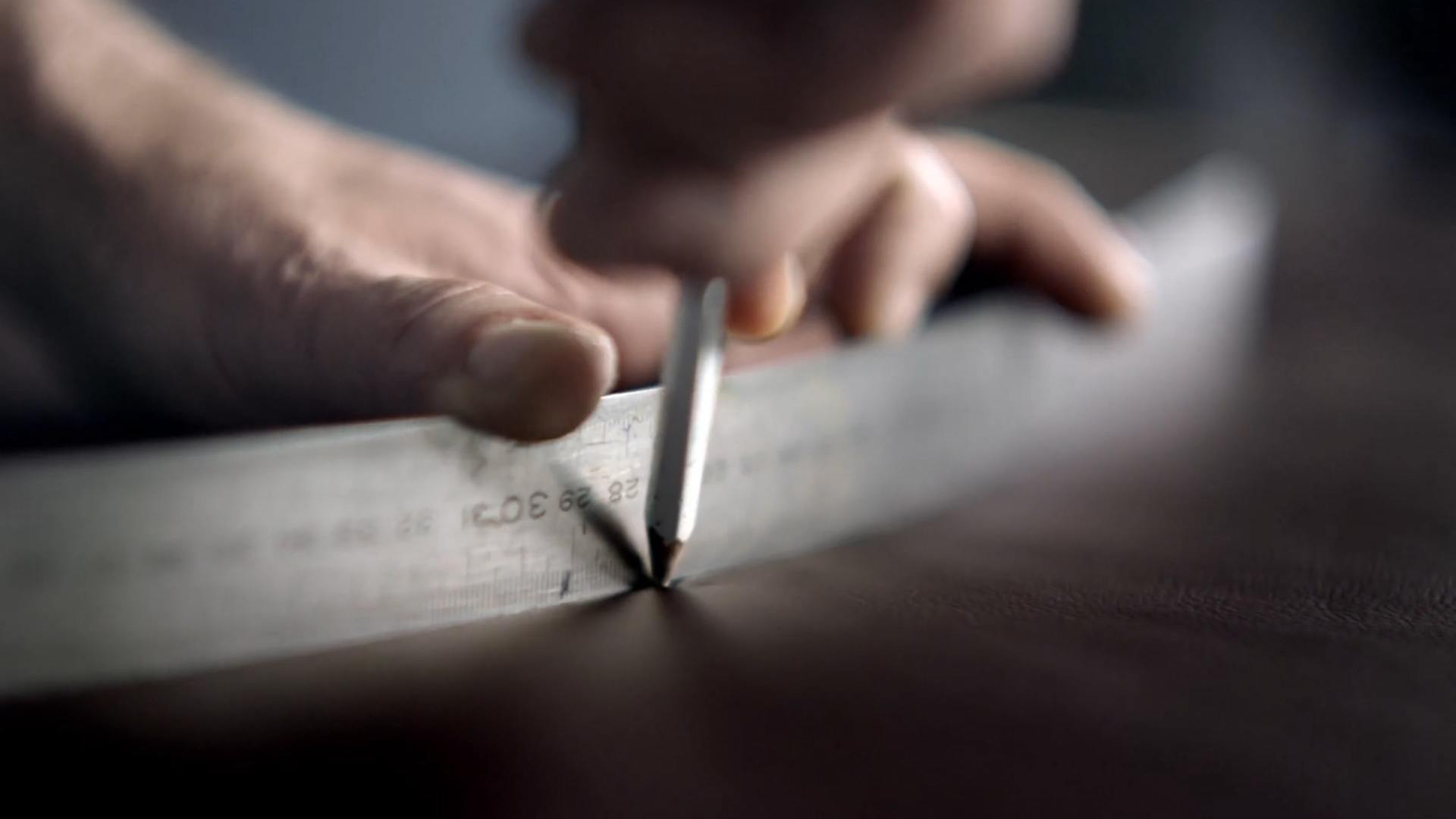 A person measuring using a ruler and a pencil