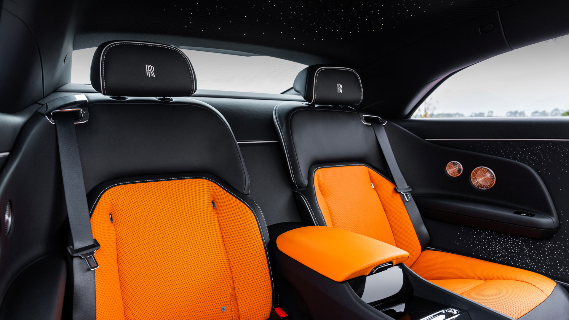Interior shot of Spectre carseats, they are black and orange.
