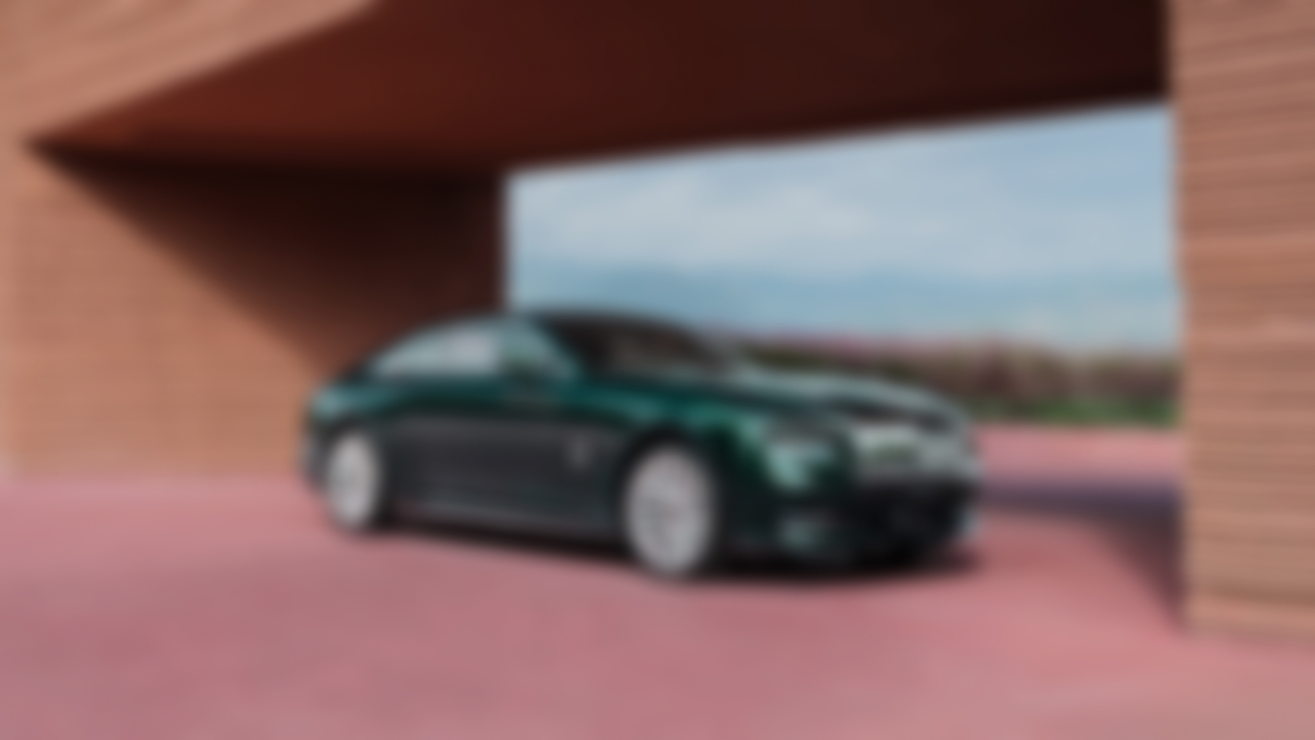 Front angled shot of a Green Spectre sitting infront of a pink flower garden.