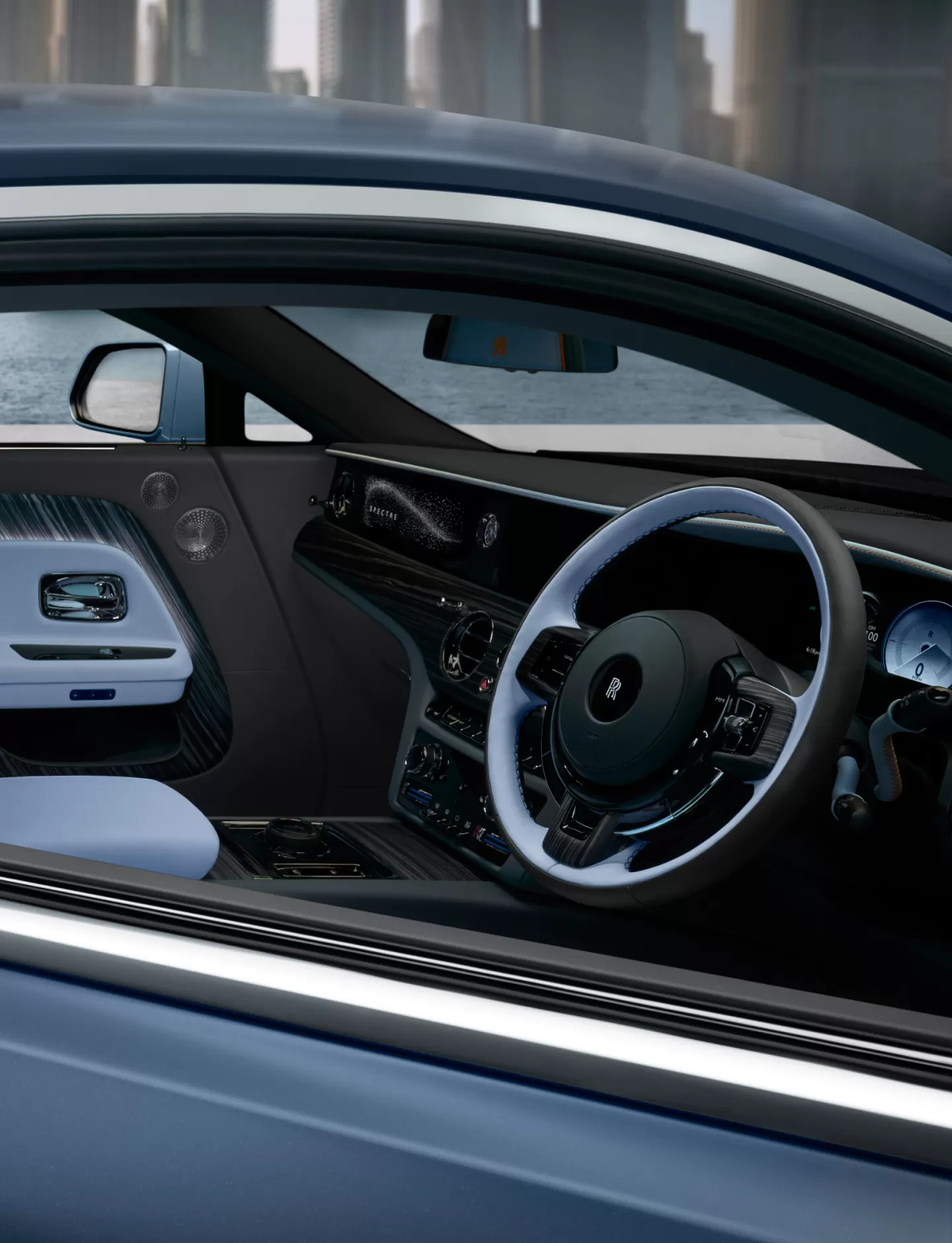 Image of inside of a blue and black Spectre showing the steering wheel and interior accents. 