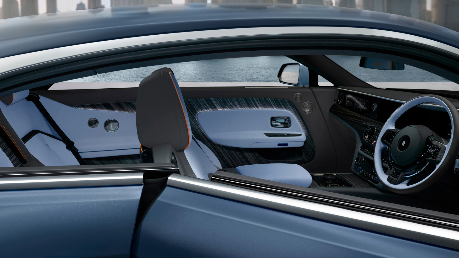 Image of inside of a blue and black Spectre showing the steering wheel and interior accents. 