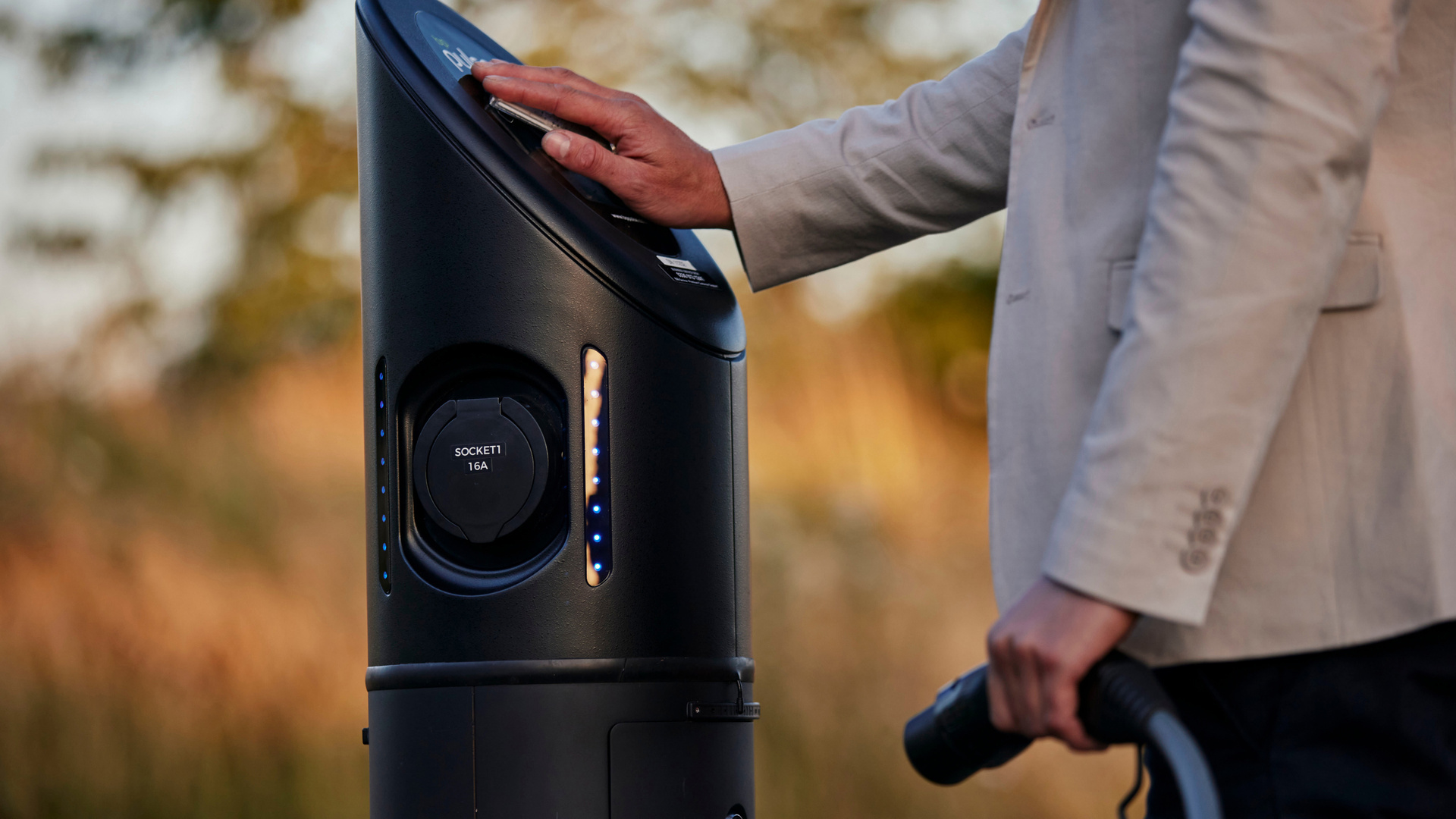 Close up of man paying to charge his Spectre at a public charging station