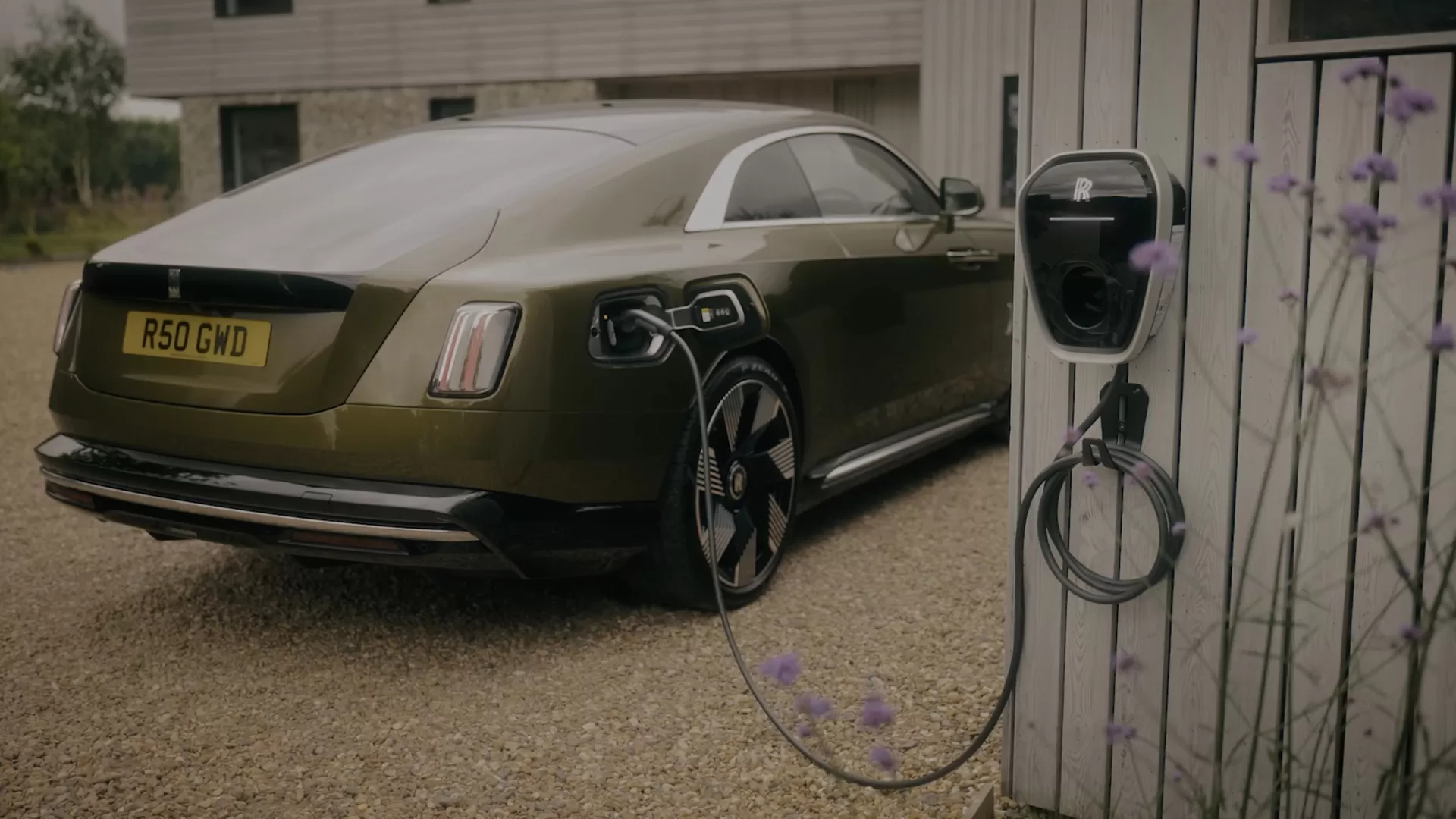 Rear three quarter view of Spectre charging at a private charging location