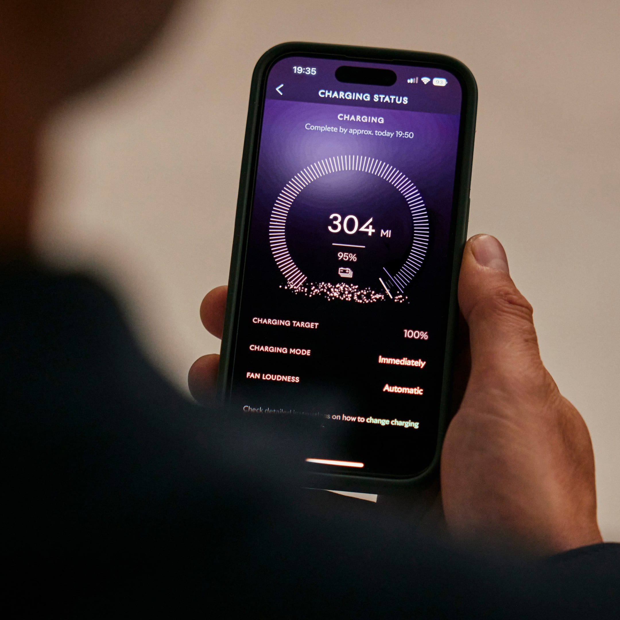 A man holding his phone viewing the Whispers app to review the charging status of his Spectre