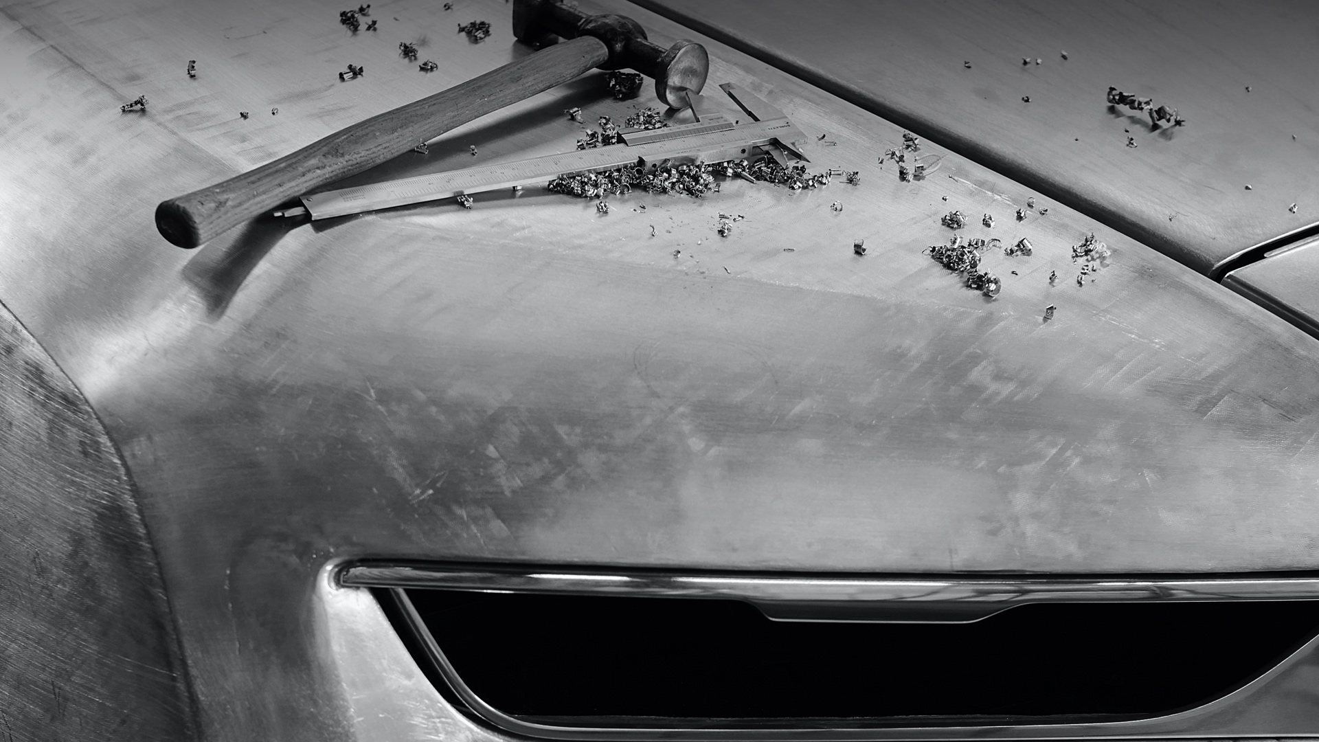 black and white image of the Boat Tail being created with hammers on top of the bonnet 